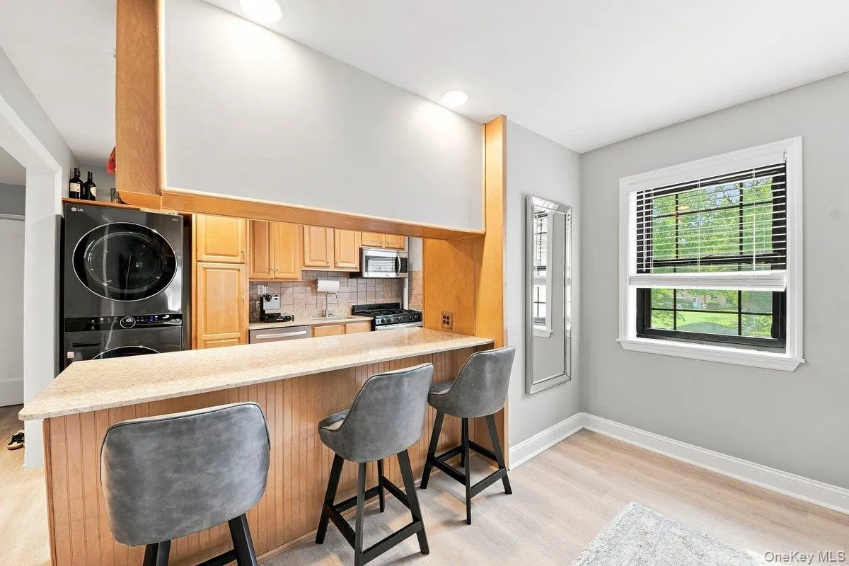 Light-filled area- a stylish marble kitchen bar, and a cozy dining space. Light-filled area- a stylish marble kitchen bar, and a cozy dining space.