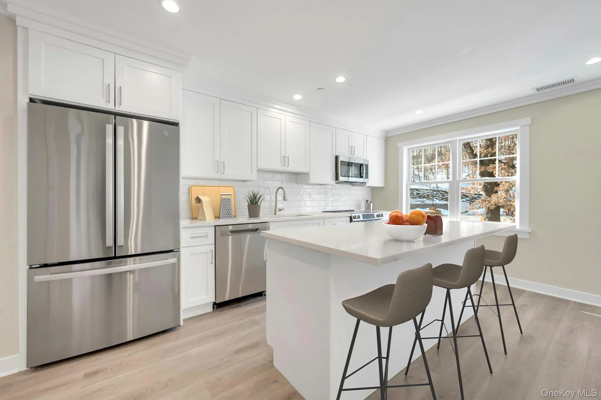 Kitchen with stainless steel appliances, tasteful backsplash, light countertops, and white cabinets Kitchen with stainless steel appliances, tasteful backsplash, light countertops, and white cabinets