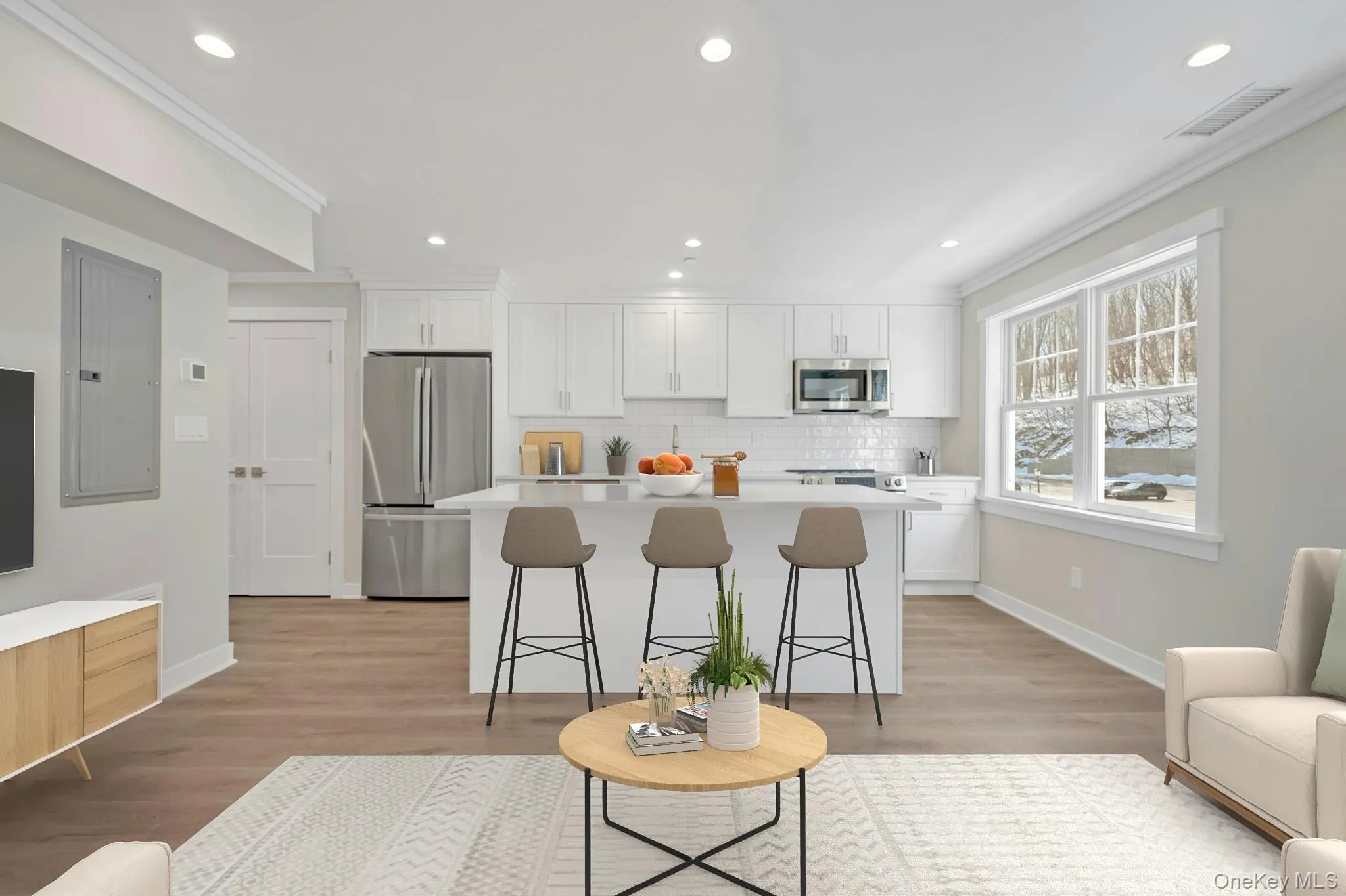 Kitchen with stainless steel appliances, light countertops, a kitchen bar, and white cabinetry Kitchen with stainless steel appliances, light countertops, a kitchen bar, and white cabinetry