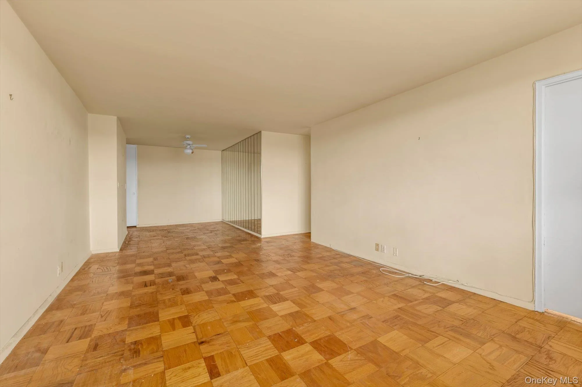 Parquet wood-finish flooring, neutral wall tones, and mirrored wall panels Parquet wood-finish flooring, neutral wall tones, and mirrored wall panels