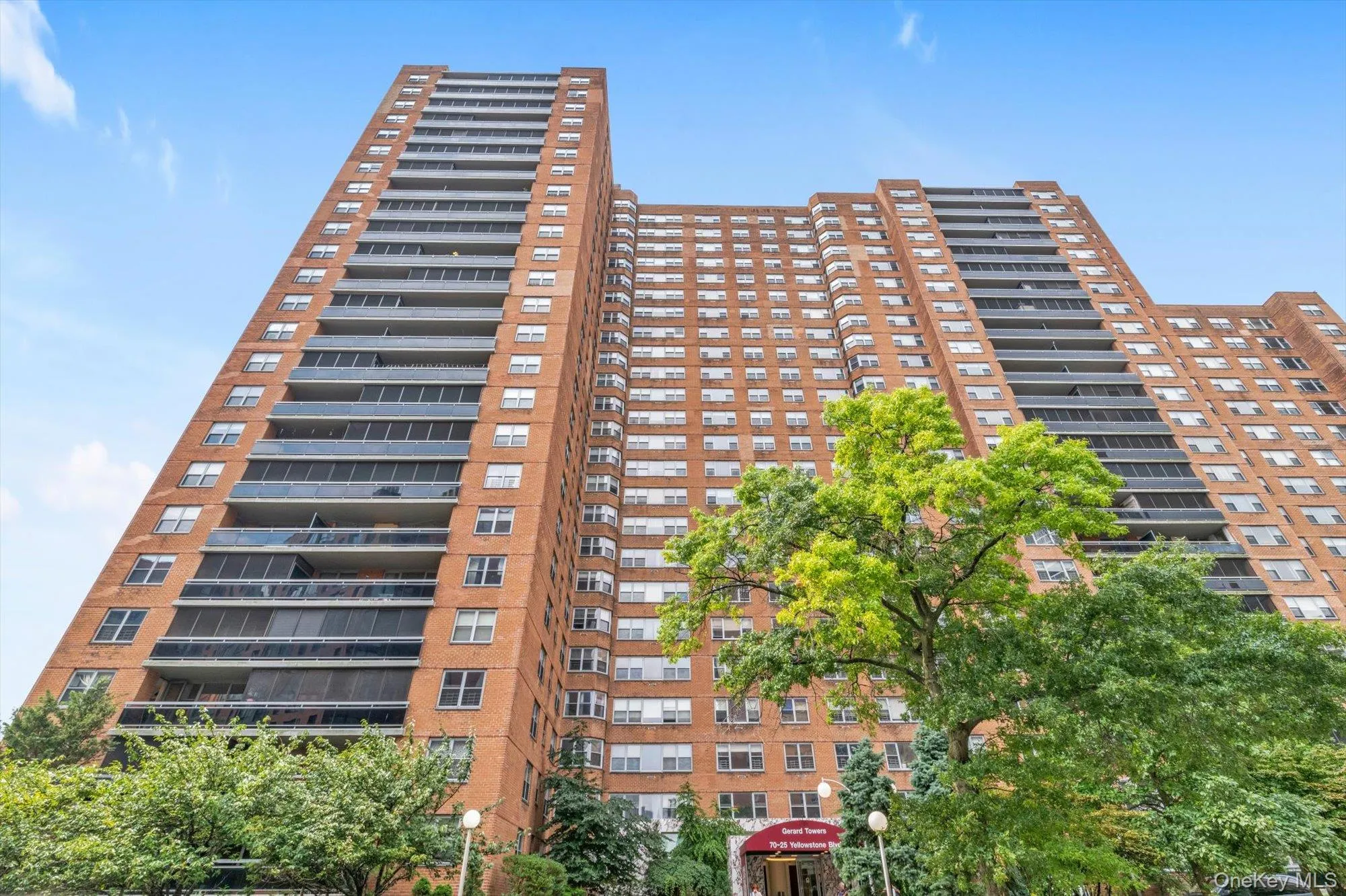 Brick facade building with multiple balconies featuring glass railings Brick facade building with multiple balconies featuring glass railings