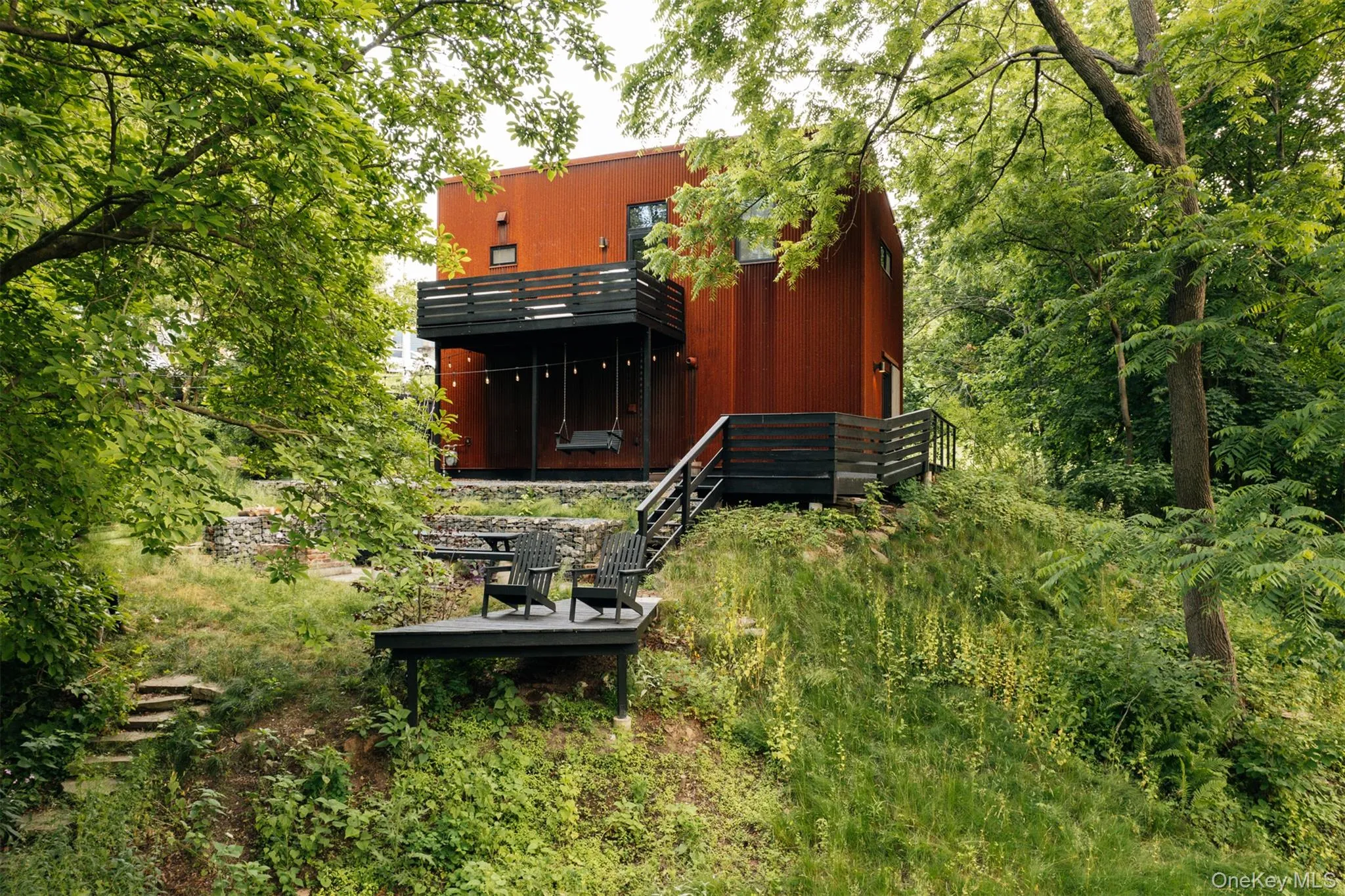 Back of property with stairway and a view of trees Back of property with stairway and a view of trees