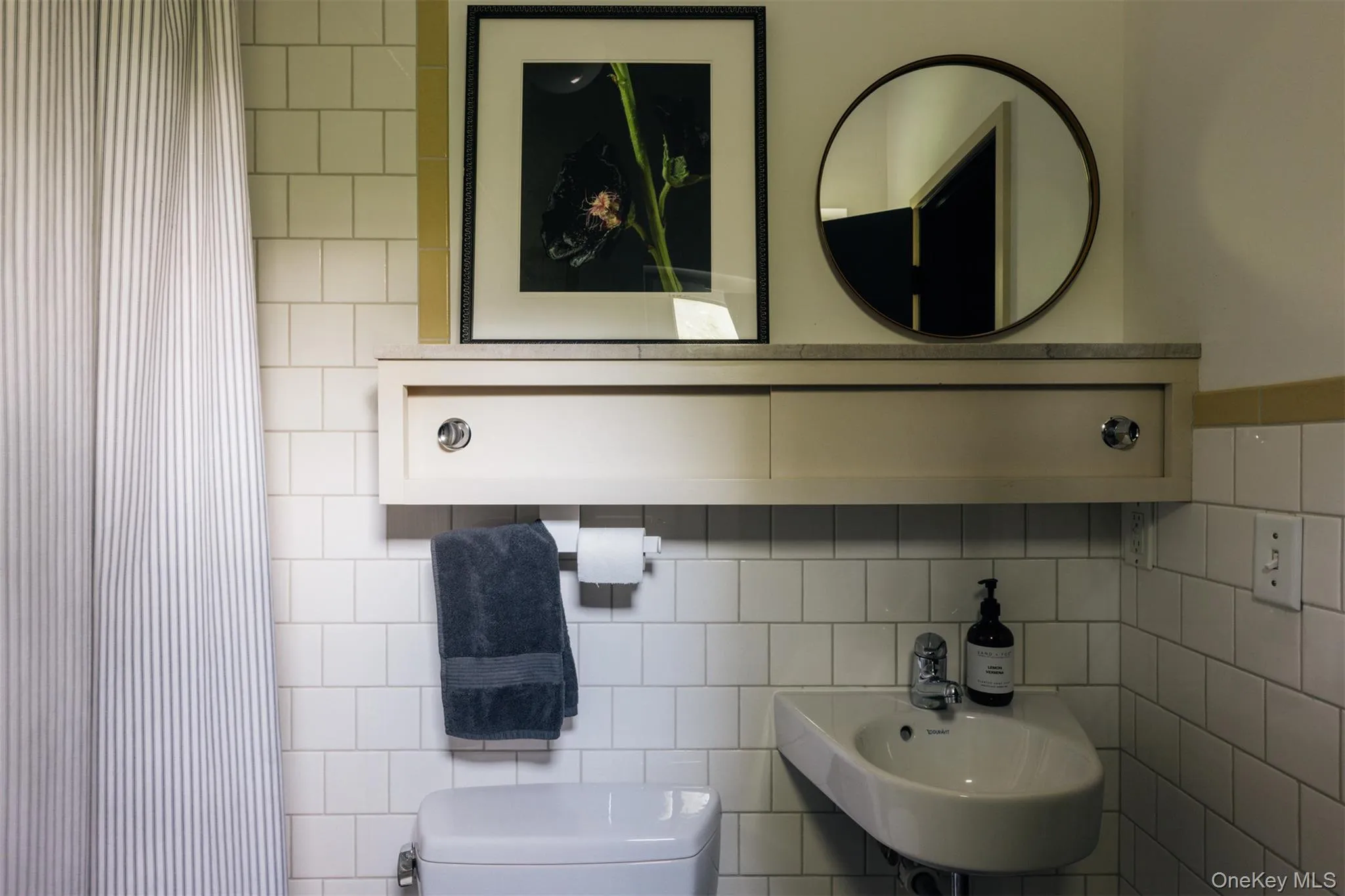 Full bathroom with curtained shower and tile walls Full bathroom with curtained shower and tile walls