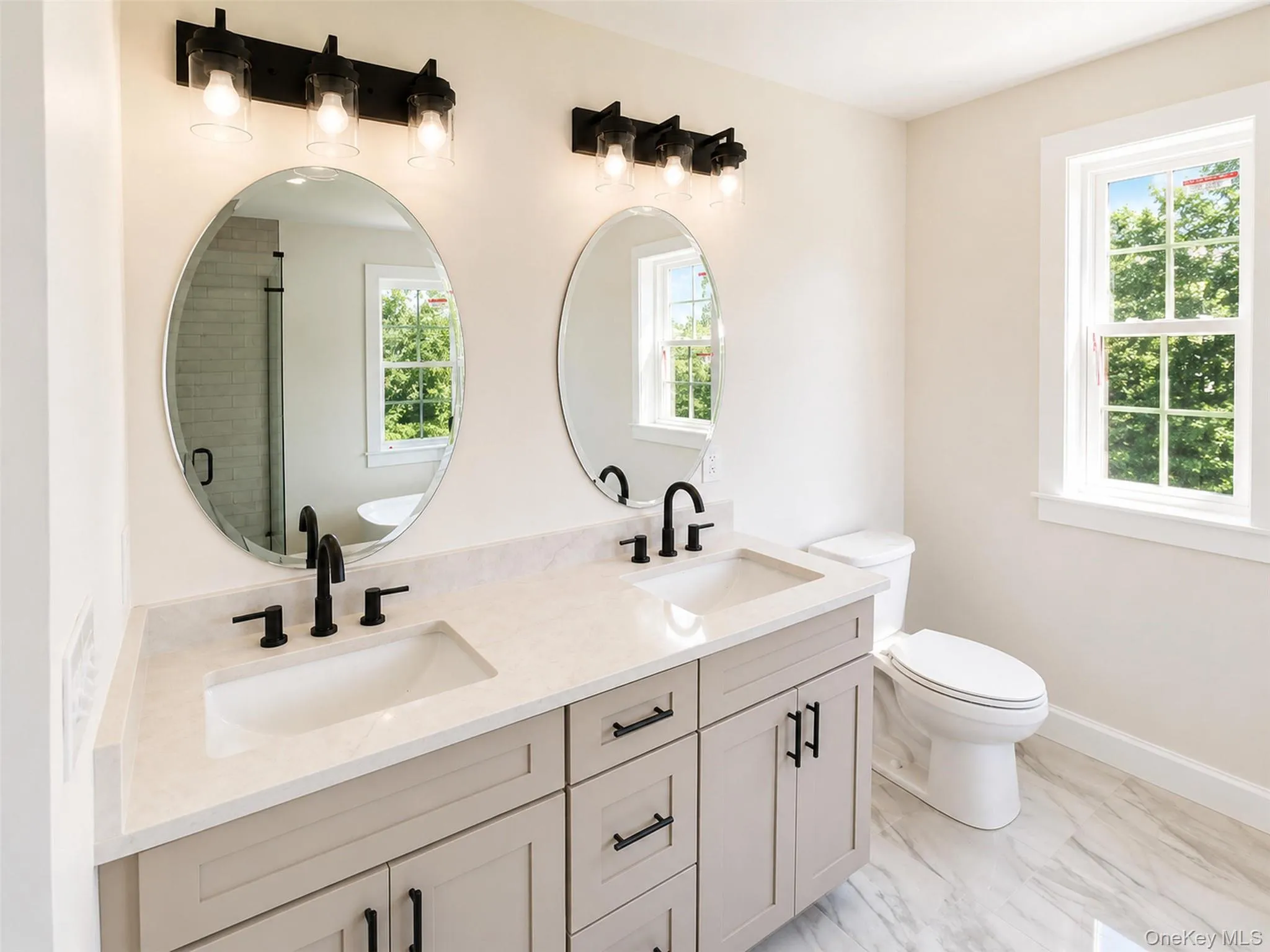 The completed dual vanity is complemented by elegant lighting, sleek fixtures, and timeless finishes that enhance the primary bath's refined design. The completed dual vanity is complemented by elegant lighting, sleek fixtures, and timeless finishes that enhance the primary bath's refined design.
