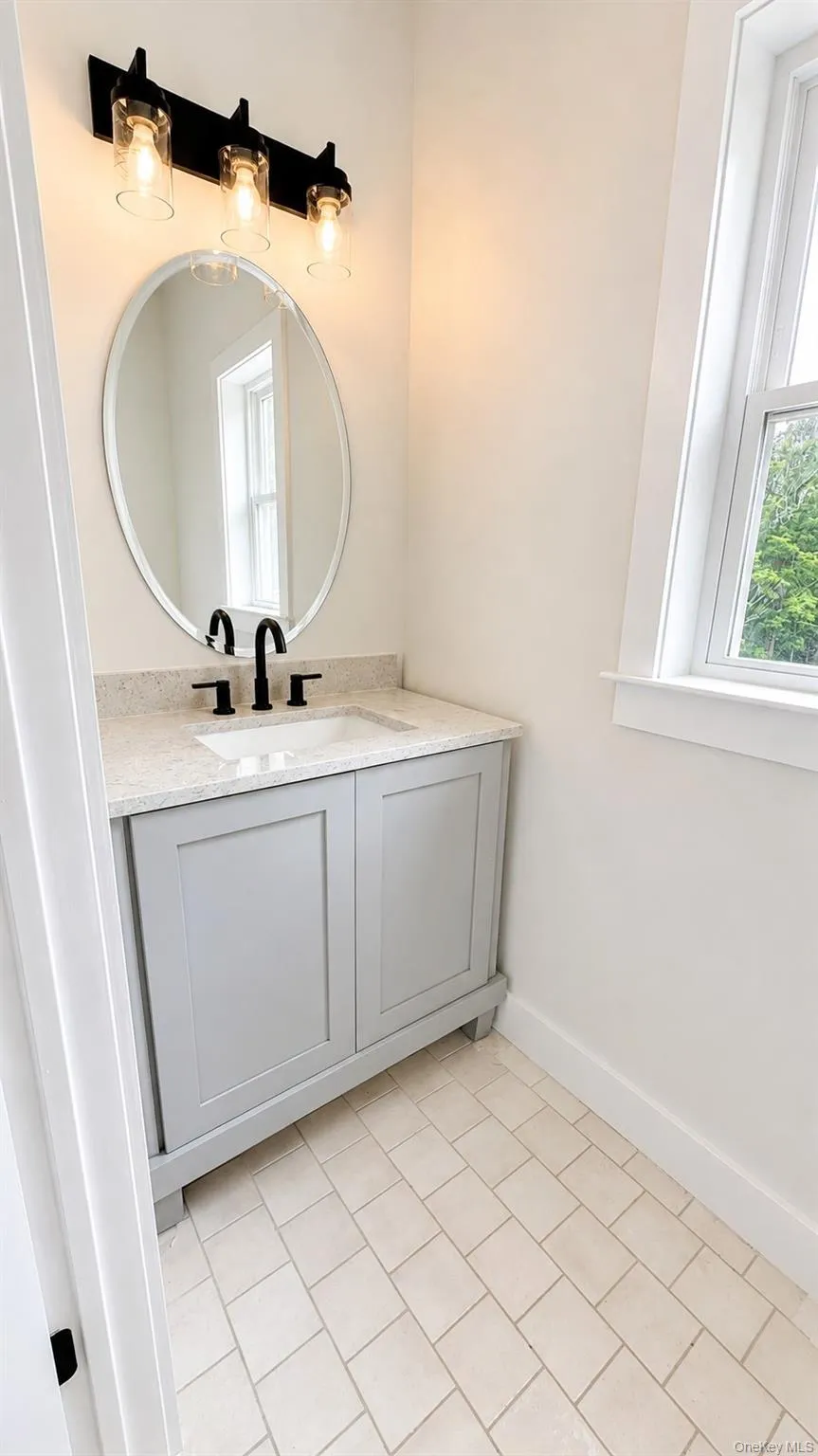 Elegant lighting, a custom vanity, and stylish finishes create a warm and welcoming space, thoughtfully designed to complement the home’s modern aesthetic. Elegant lighting, a custom vanity, and stylish finishes create a warm and welcoming space, thoughtfully designed to complement the home’s modern aesthetic.
