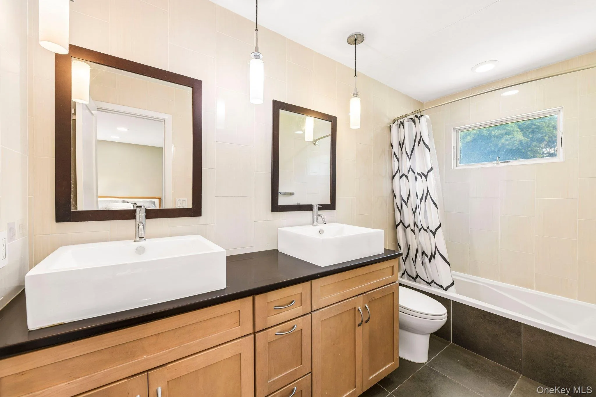 Double vanity Primary Bathroom. Floor to ceiling tiled floor and walls, quartz counter top with pendant, high hat lights and radiant heated floor. Double vanity Primary Bathroom. Floor to ceiling tiled floor and walls, quartz counter top with pendant, high hat lights and radiant heated floor.