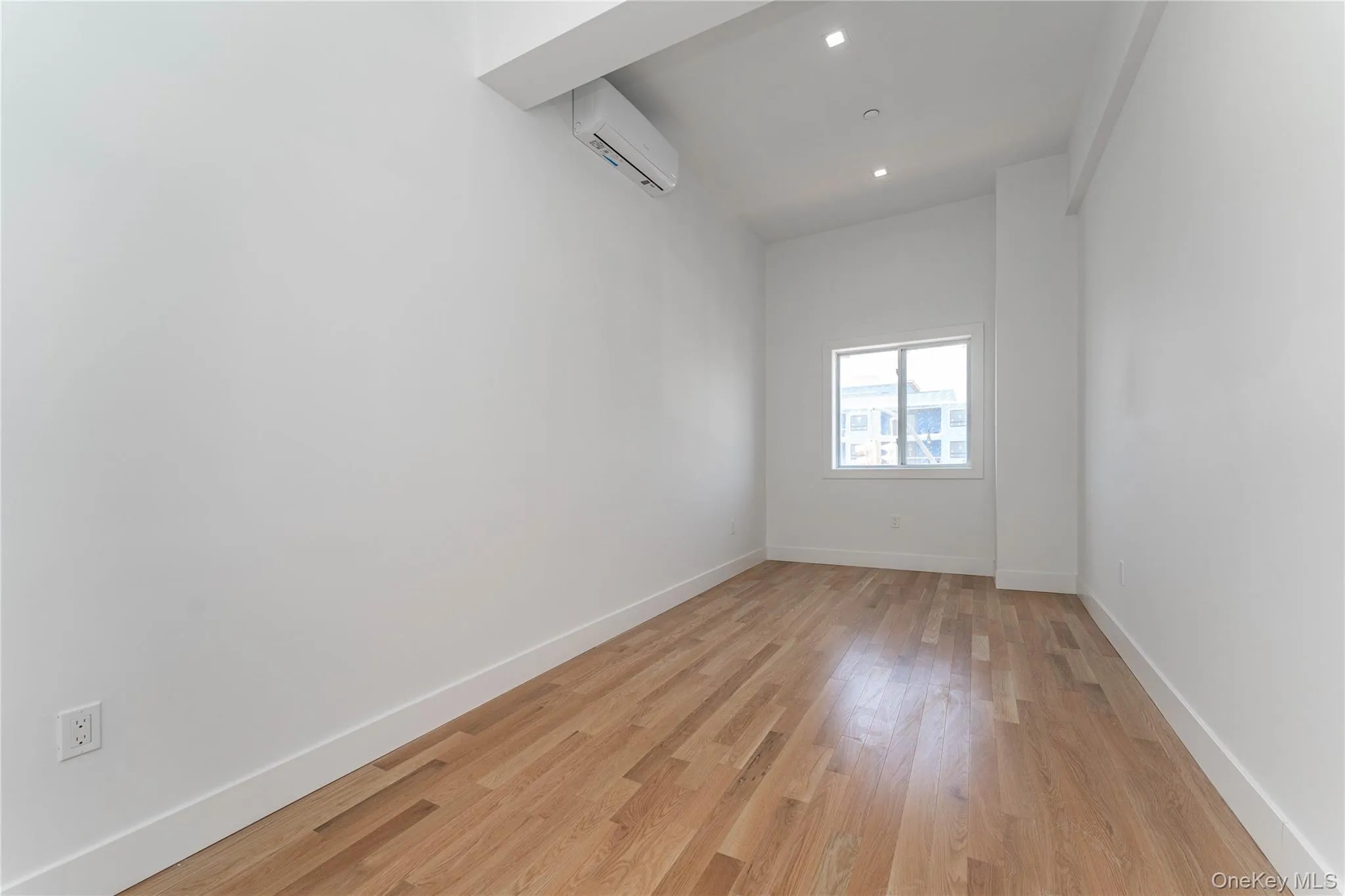 Unfurnished room featuring an AC wall unit, light wood-style flooring, baseboards, and recessed lighting Unfurnished room featuring an AC wall unit, light wood-style flooring, baseboards, and recessed lighting