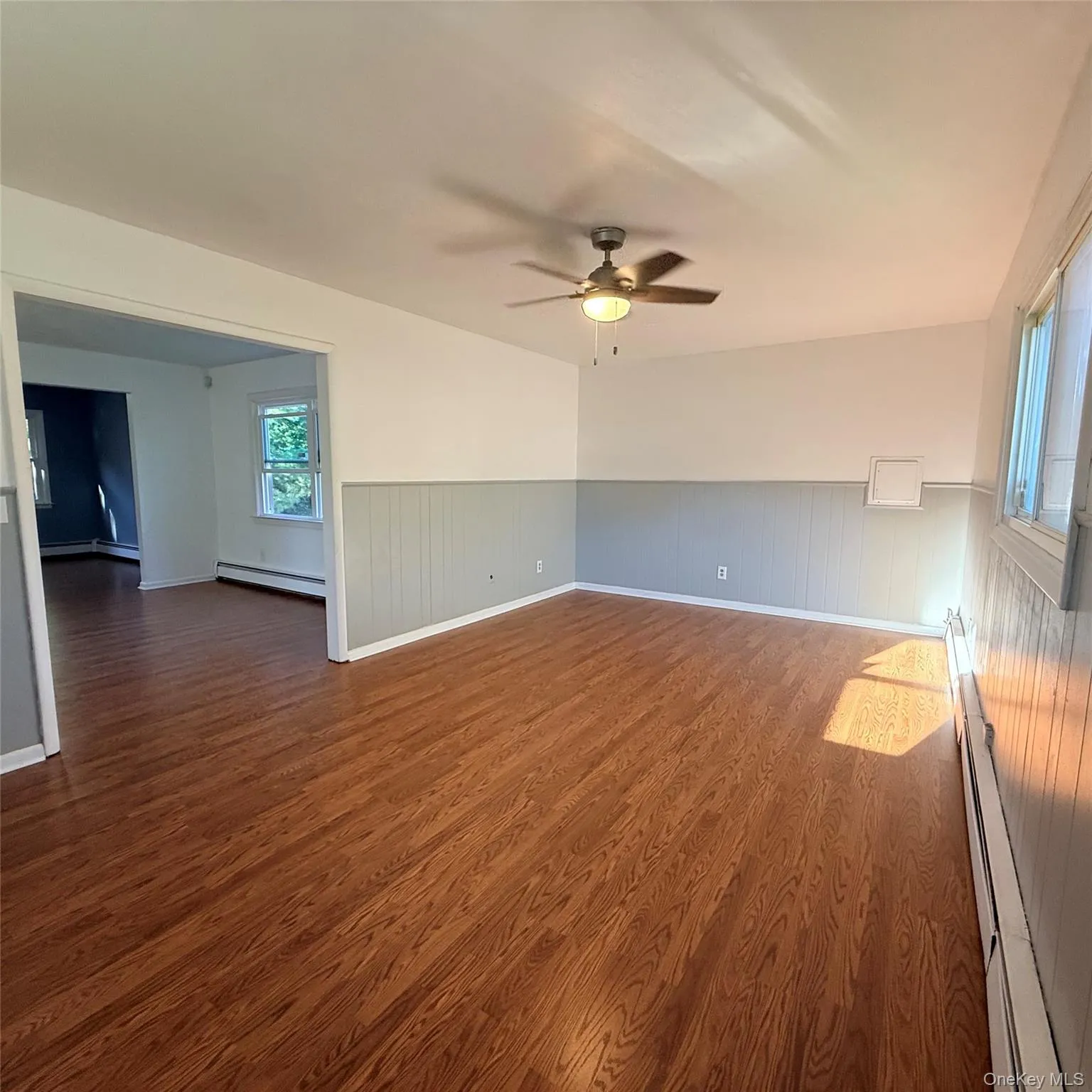 Wood-finish flooring, two-tone wall treatment, and a ceiling fan with integrated lighting Wood-finish flooring, two-tone wall treatment, and a ceiling fan with integrated lighting