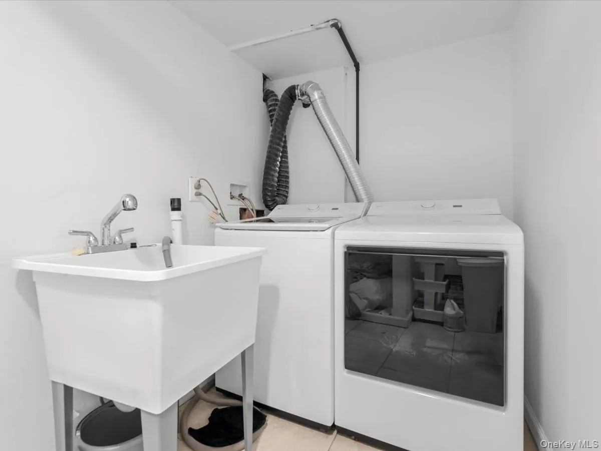 Laundry appliances with a utility sink featuring a chrome faucet Laundry appliances with a utility sink featuring a chrome faucet