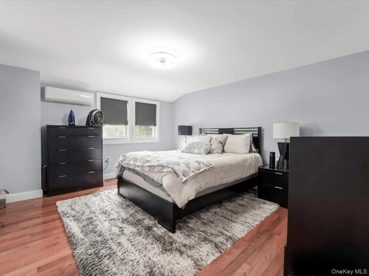Primary Bedroom: Spacious and bright with hardwood floors, recessed lighting, multiple windows, and a split A/C unit. Primary Bedroom: Spacious and bright with hardwood floors, recessed lighting, multiple windows, and a split A/C unit.