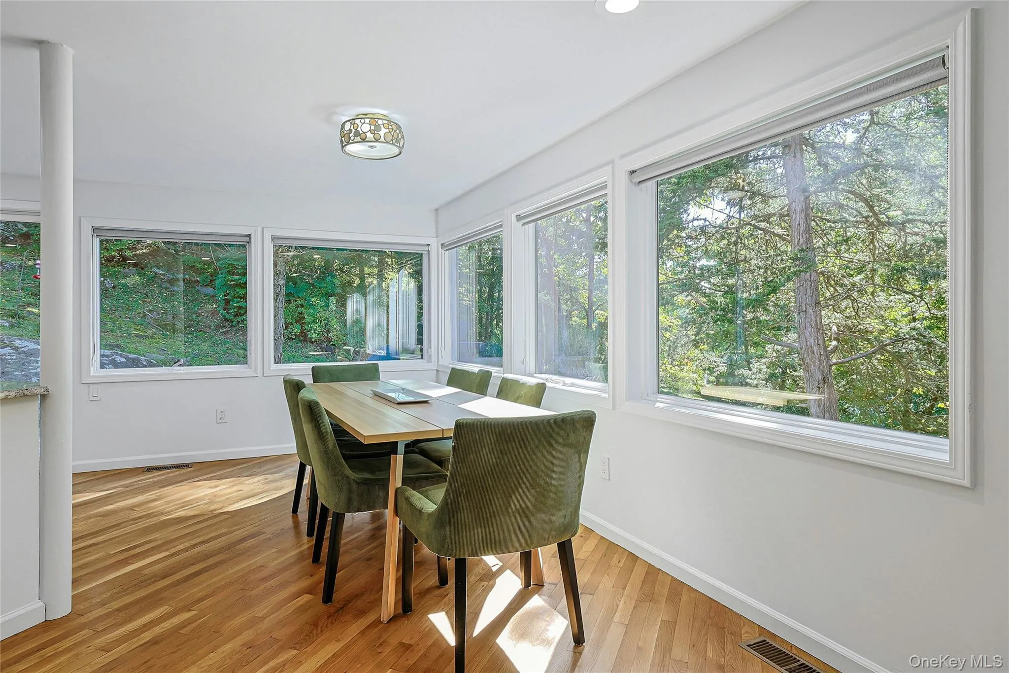 Gather around the table and take in the peaceful wooded views, with windows framing the private setting and creating a warm backdrop Gather around the table and take in the peaceful wooded views, with windows framing the private setting and creating a warm backdrop