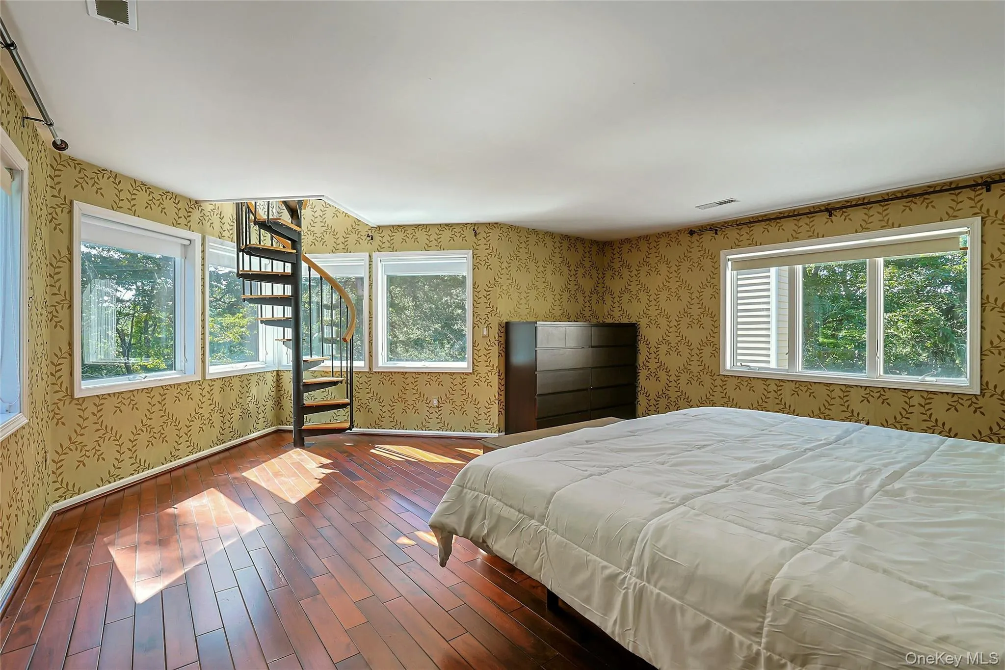 Spacious primary bedroom with walls of windows that bring in abundant natural light and showcase the surrounding views. Spacious primary bedroom with walls of windows that bring in abundant natural light and showcase the surrounding views.