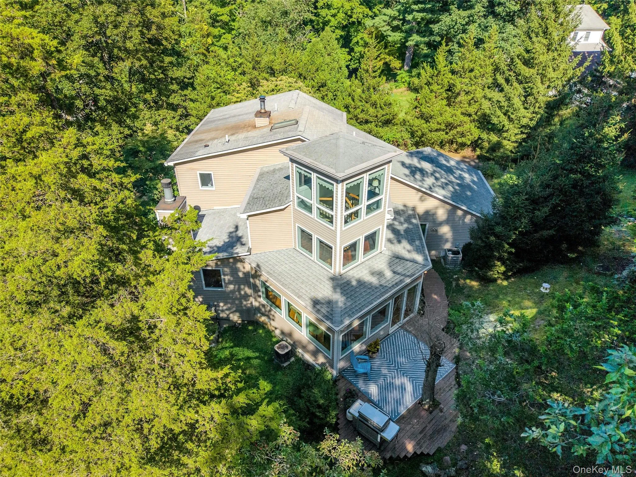 A beautiful rear view highlights the home’s unique architecture and picturesque setting, with the distinctive “Crow’s Nest” adding even more character. A beautiful rear view highlights the home’s unique architecture and picturesque setting, with the distinctive “Crow’s Nest” adding even more character.