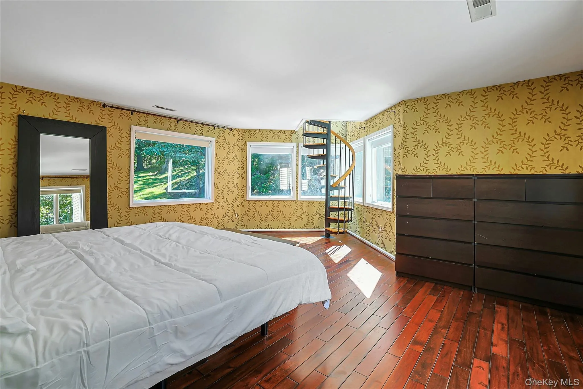 Primary bedroom features a spiral staircase leading to the “Crow’s Nest,” a unique upper-level space accessed directly from the bedroom. Primary bedroom features a spiral staircase leading to the “Crow’s Nest,” a unique upper-level space accessed directly from the bedroom.