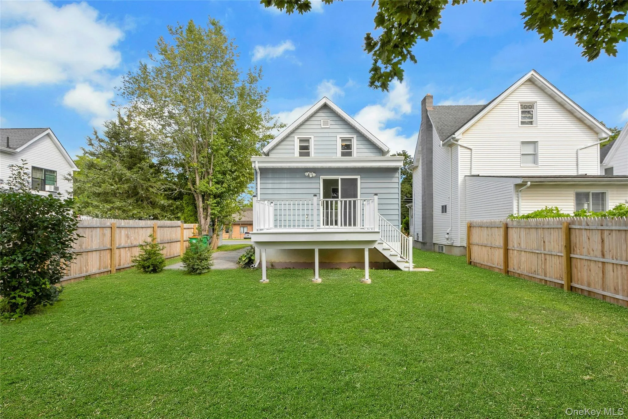 Private backyard featuring a manicured lawn, wood fencing, and an oversized deck perfect for outdoor dining. Private backyard featuring a manicured lawn, wood fencing, and an oversized deck perfect for outdoor dining.