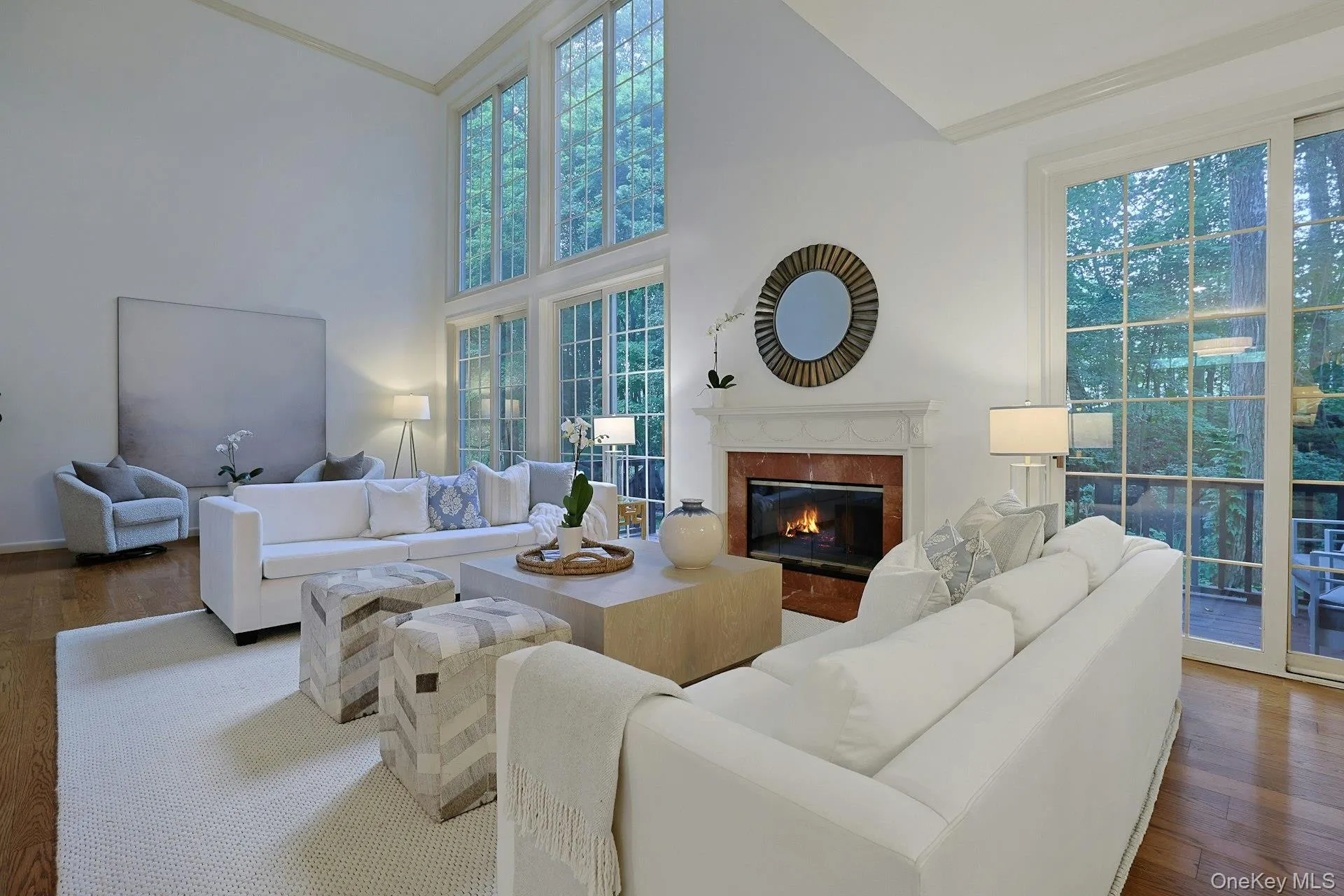 Dramatic double-height living room with wood-burning fireplace, walls of glass and a serene outlook onto the private landscape. Dramatic double-height living room with wood-burning fireplace, walls of glass and a serene outlook onto the private landscape.