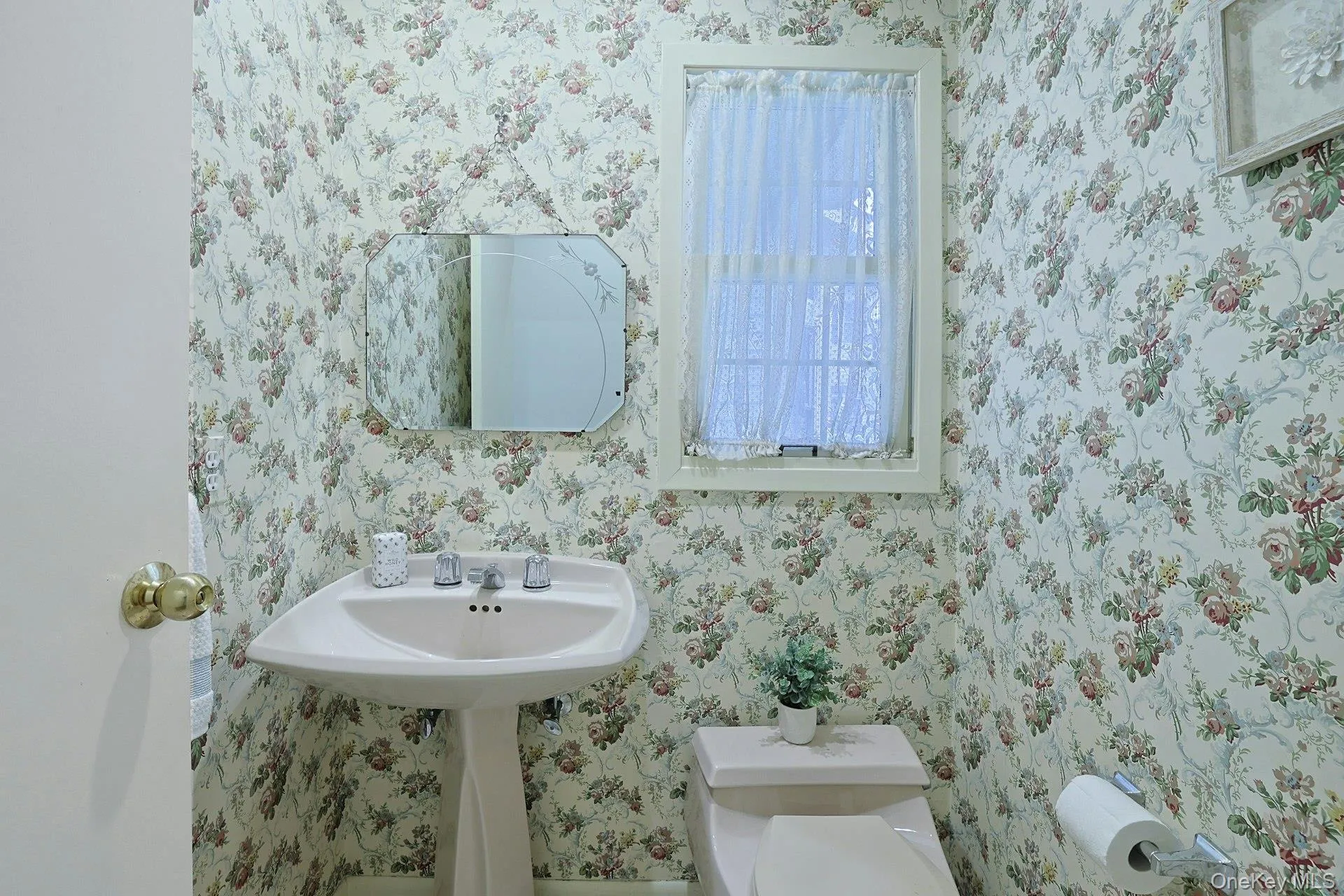 Conveniently located first-floor powder room with a classic pedestal sink. Conveniently located first-floor powder room with a classic pedestal sink.