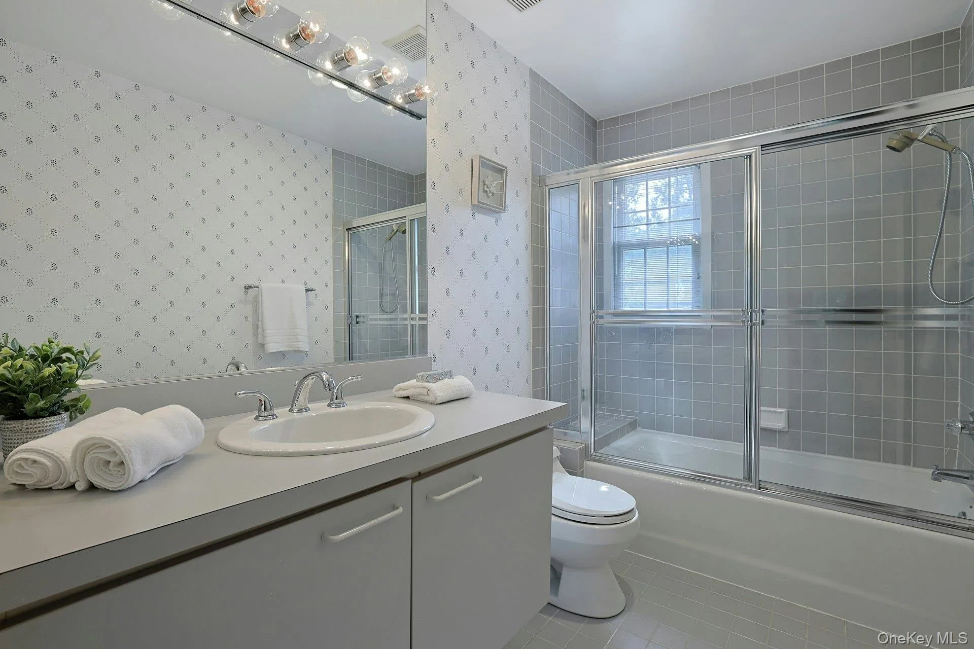 Well-proportioned hall bath serves the secondary bedrooms and features a large vanity and tub/shower with glass enclosure. Well-proportioned hall bath serves the secondary bedrooms and features a large vanity and tub/shower with glass enclosure.