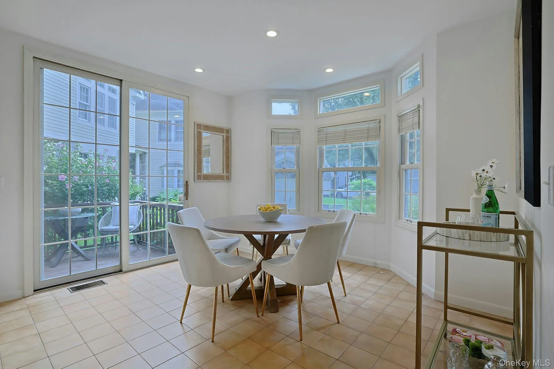 Sunny breakfast area surrounded by windows with sliding doors to a side deck—an inviting spot for casual meals, morning coffee or a BBQ. Sunny breakfast area surrounded by windows with sliding doors to a side deck—an inviting spot for casual meals, morning coffee or a BBQ.