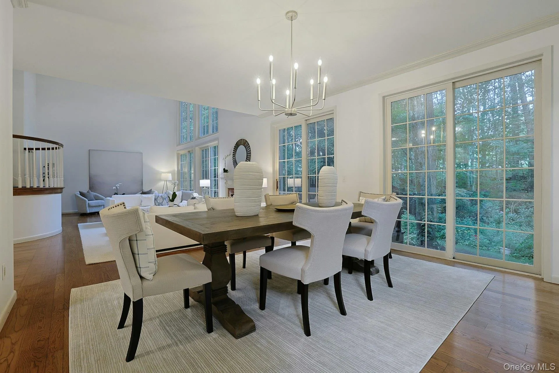 Sliding glass doors connect the dining area to the deck and surrounding greenery, extending entertaining effortlessly outdoors. Sliding glass doors connect the dining area to the deck and surrounding greenery, extending entertaining effortlessly outdoors.