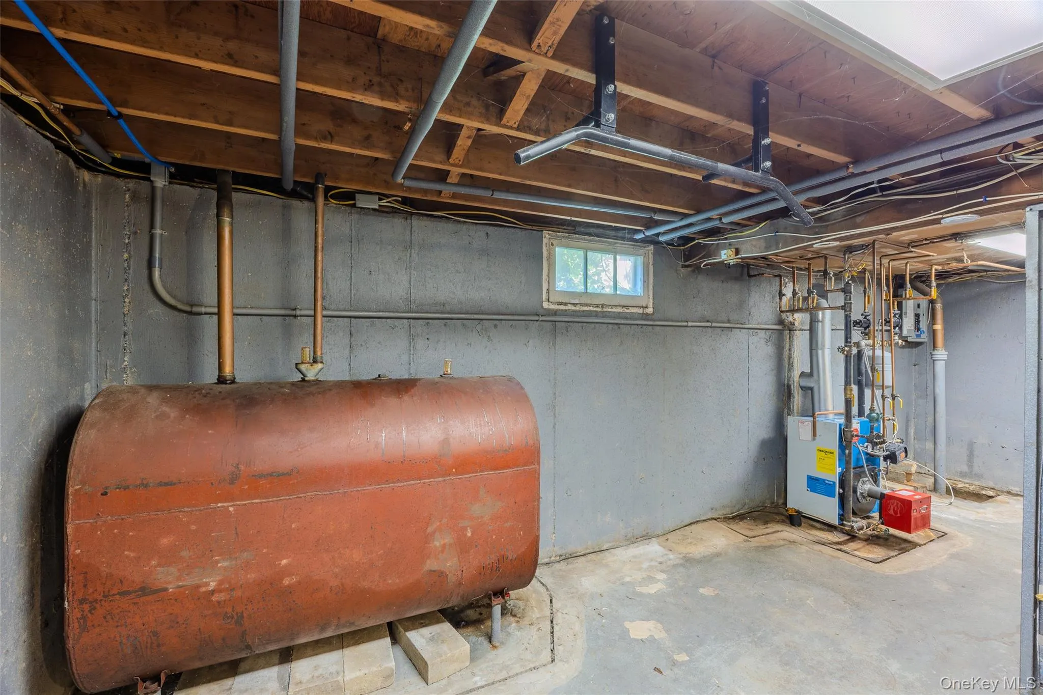 Utility area in basement showing oil tank and burner Utility area in basement showing oil tank and burner