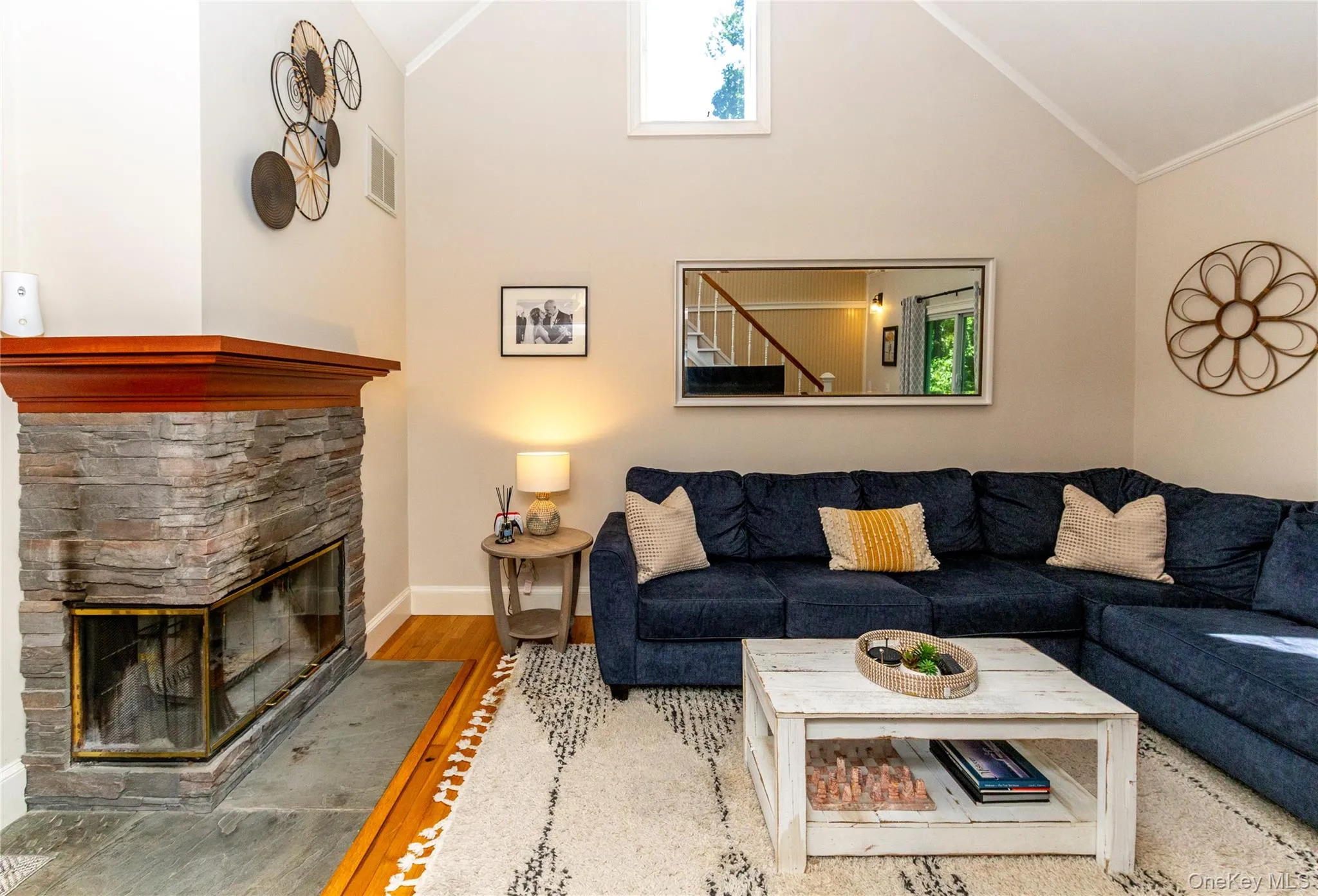 Vaulted ceiling and corner fireplace surrounded by stone. Vaulted ceiling and corner fireplace surrounded by stone.