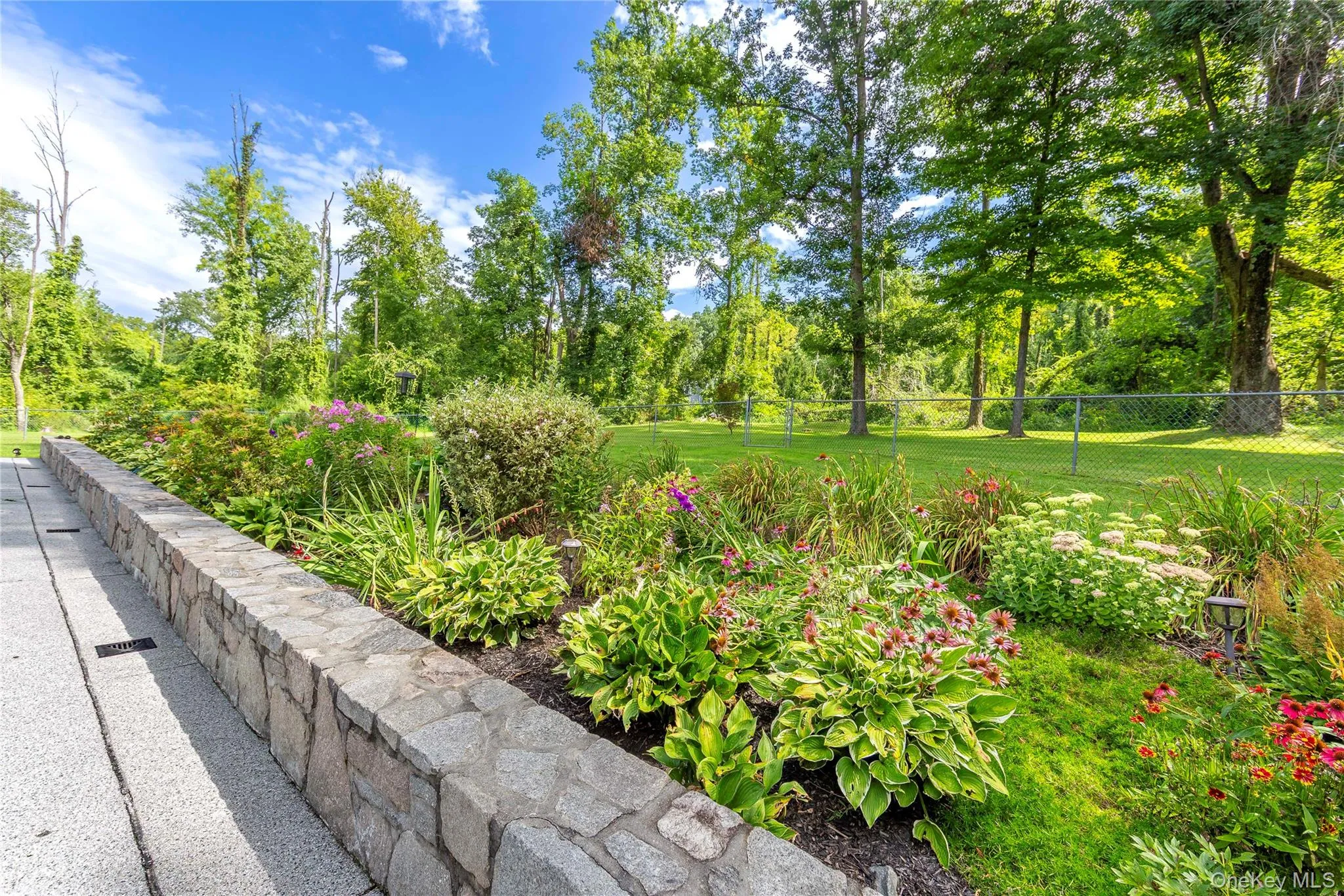 Perennial plants gives you colorful flowers and foliage that return year after year. Framed by a beautiful stone wall. Perennial plants gives you colorful flowers and foliage that return year after year. Framed by a beautiful stone wall.