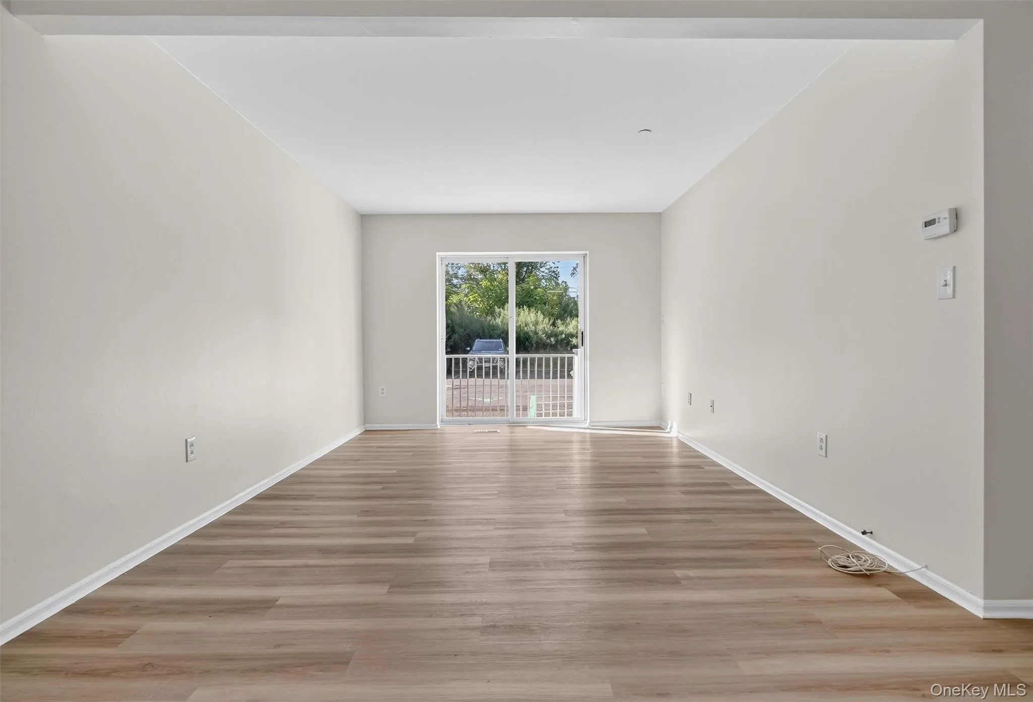Empty room with light wood-style floors and baseboards Empty room with light wood-style floors and baseboards