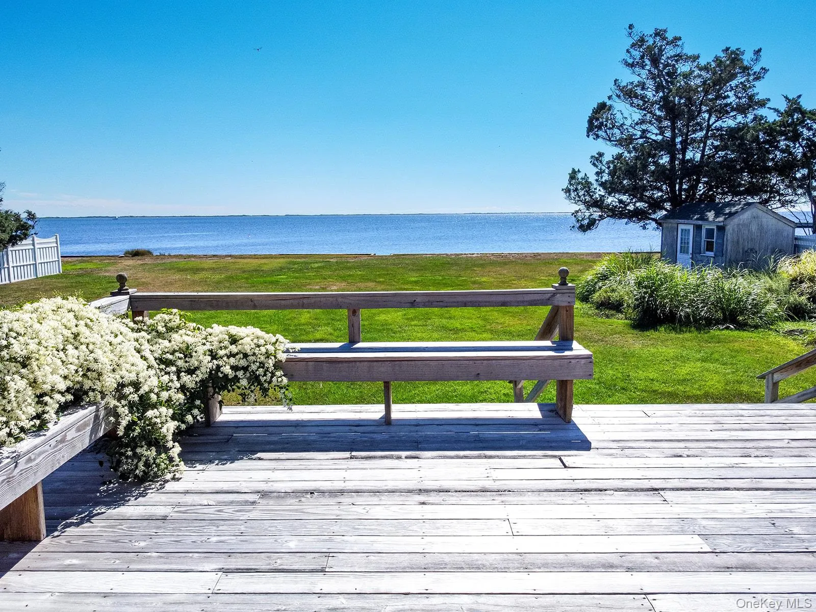 Wooden deck featuring a water view and a yard Wooden deck featuring a water view and a yard