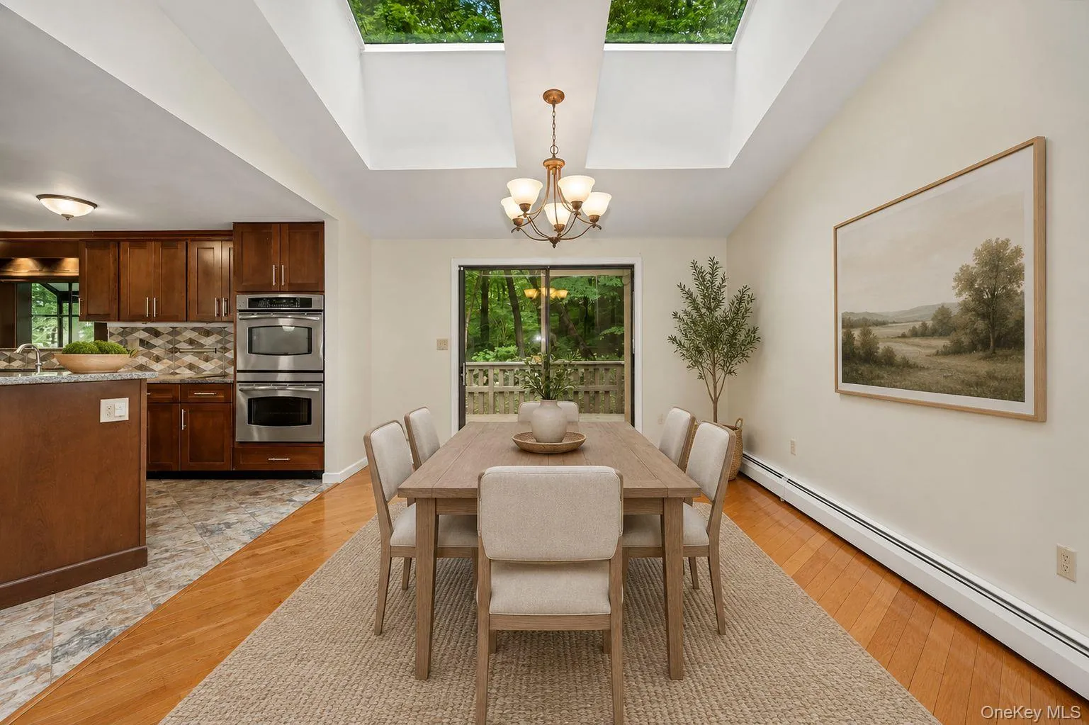 Dining area with natural light beaming from skylights and sliding glass door to deck.Virtually staged. Dining area with natural light beaming from skylights and sliding glass door to deck.Virtually staged.