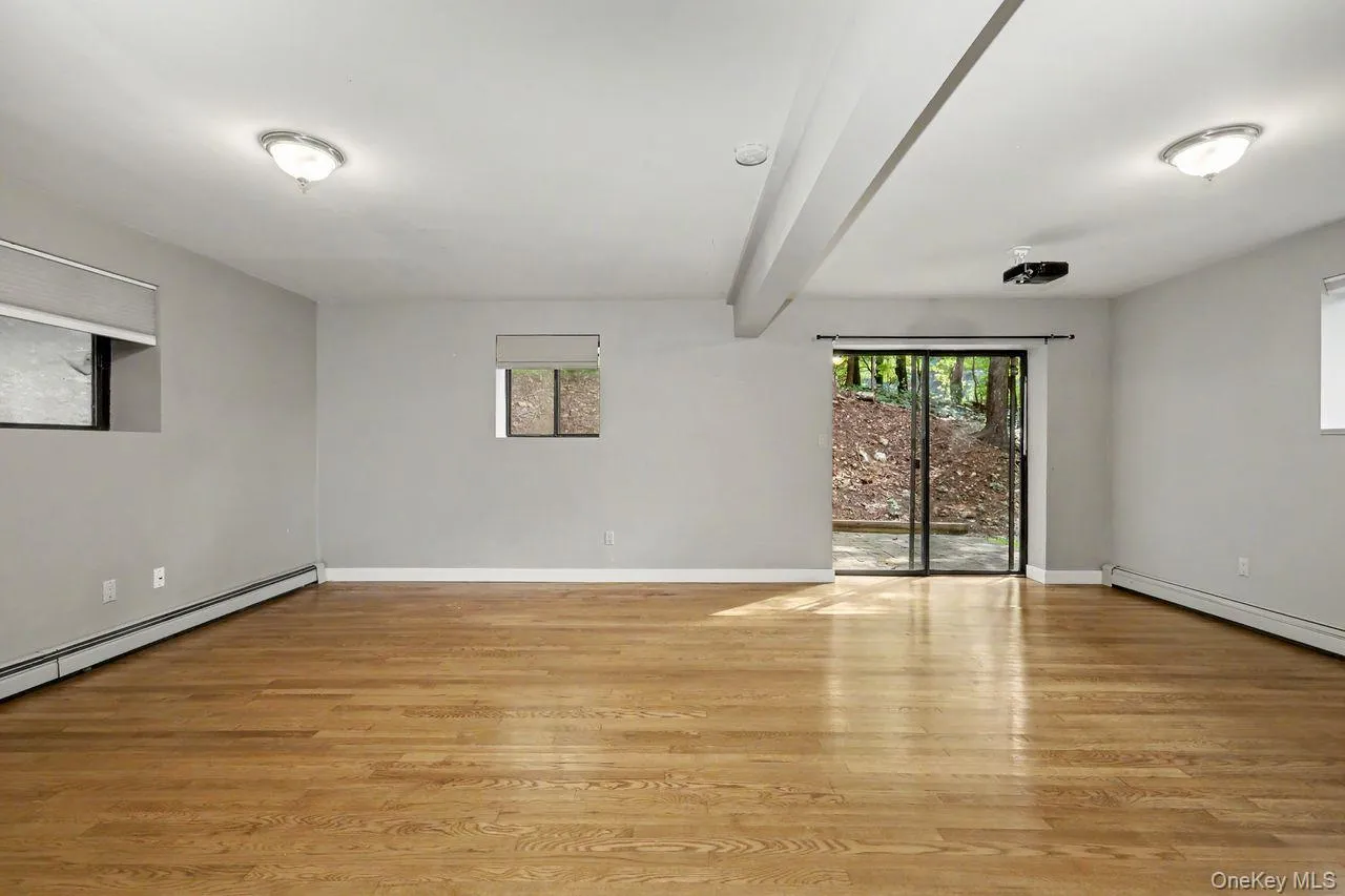 Lower level family room with sliding glass doors leading to small side patio. Lower level family room with sliding glass doors leading to small side patio.