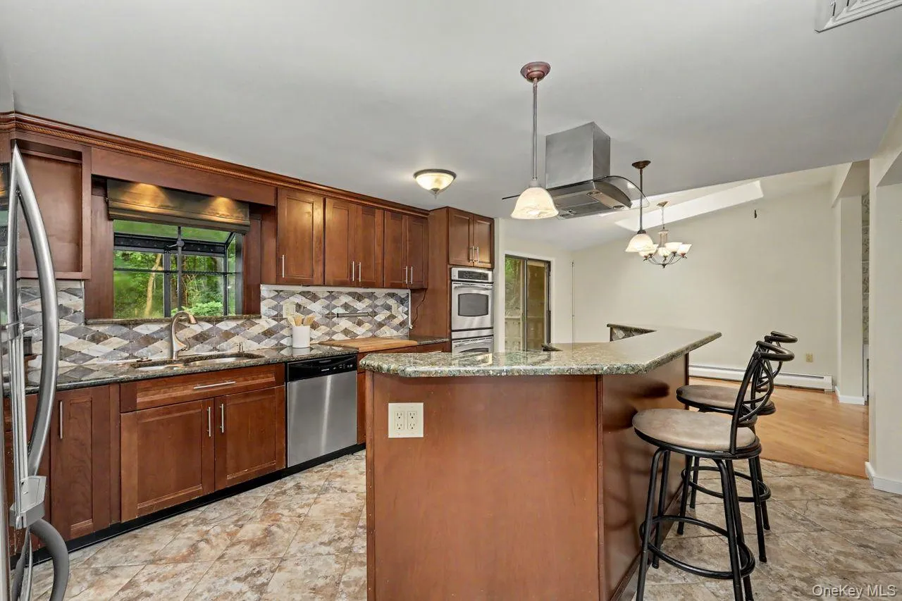 Open concept kitchen with granite countertops and island leading to living/dining room. Open concept kitchen with granite countertops and island leading to living/dining room.