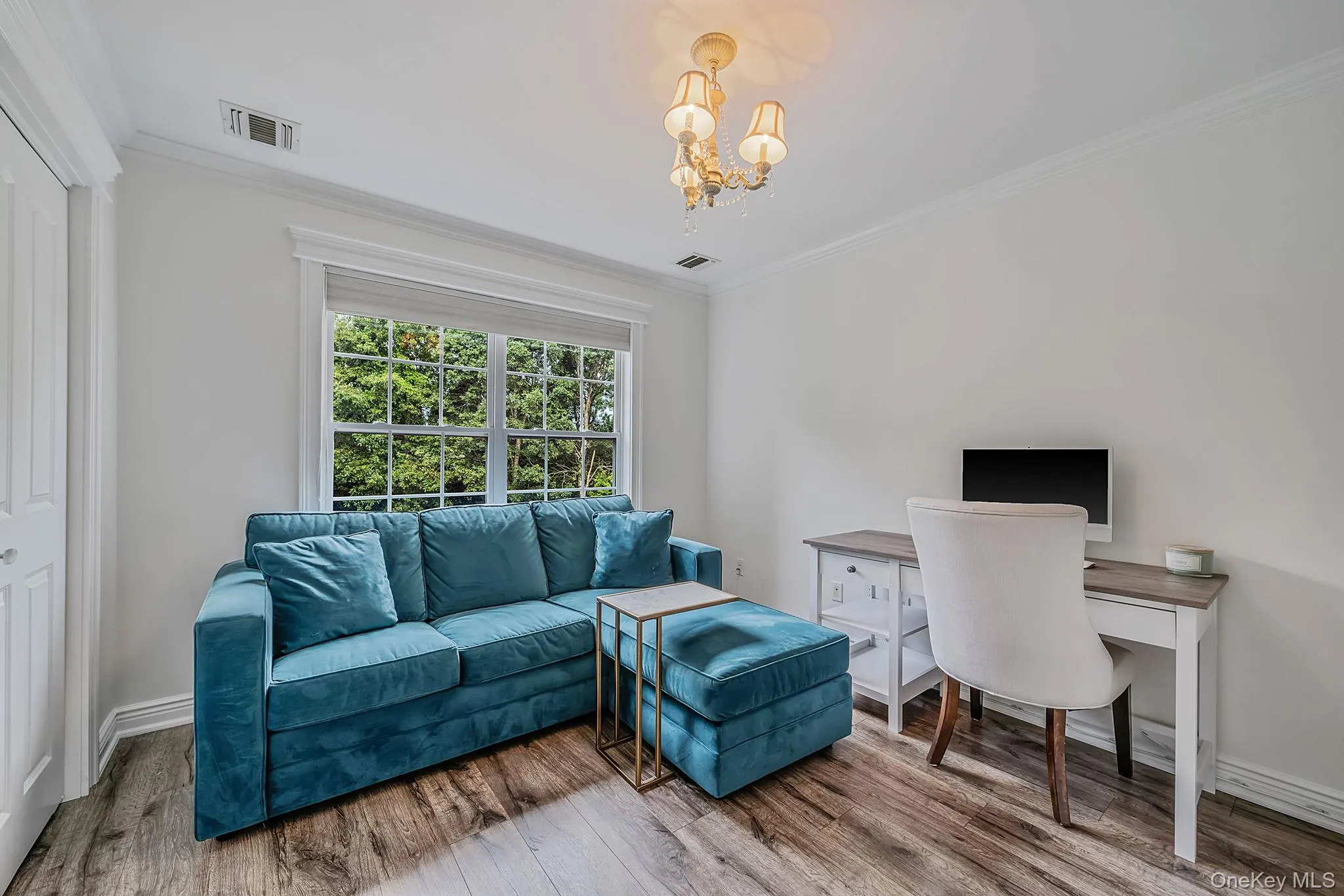 Wood-finish flooring, white walls, and a multi-pane window with a light-filtering shade Wood-finish flooring, white walls, and a multi-pane window with a light-filtering shade