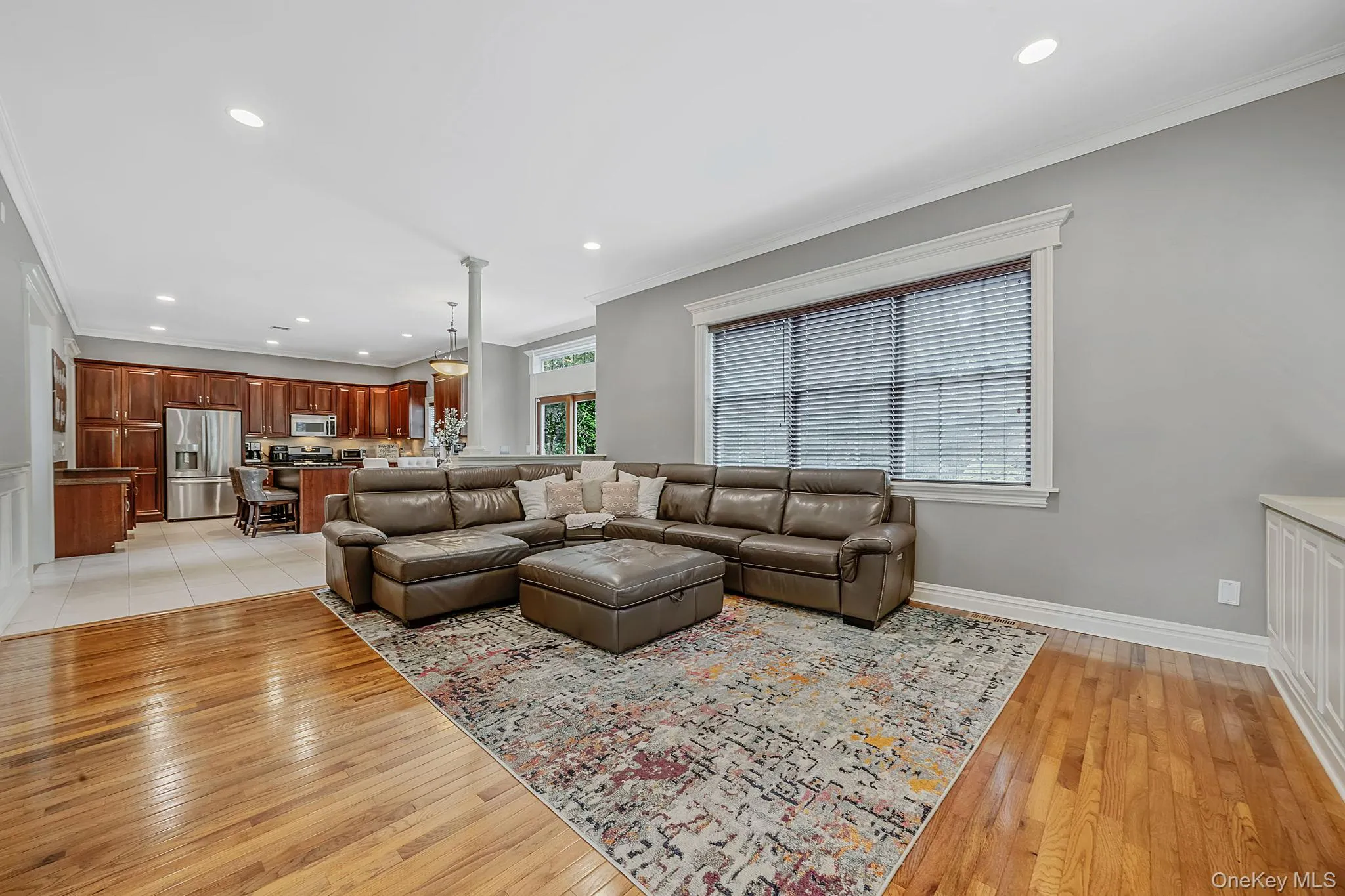 Hardwood flooring, recessed lighting, and a large window with blinds Hardwood flooring, recessed lighting, and a large window with blinds