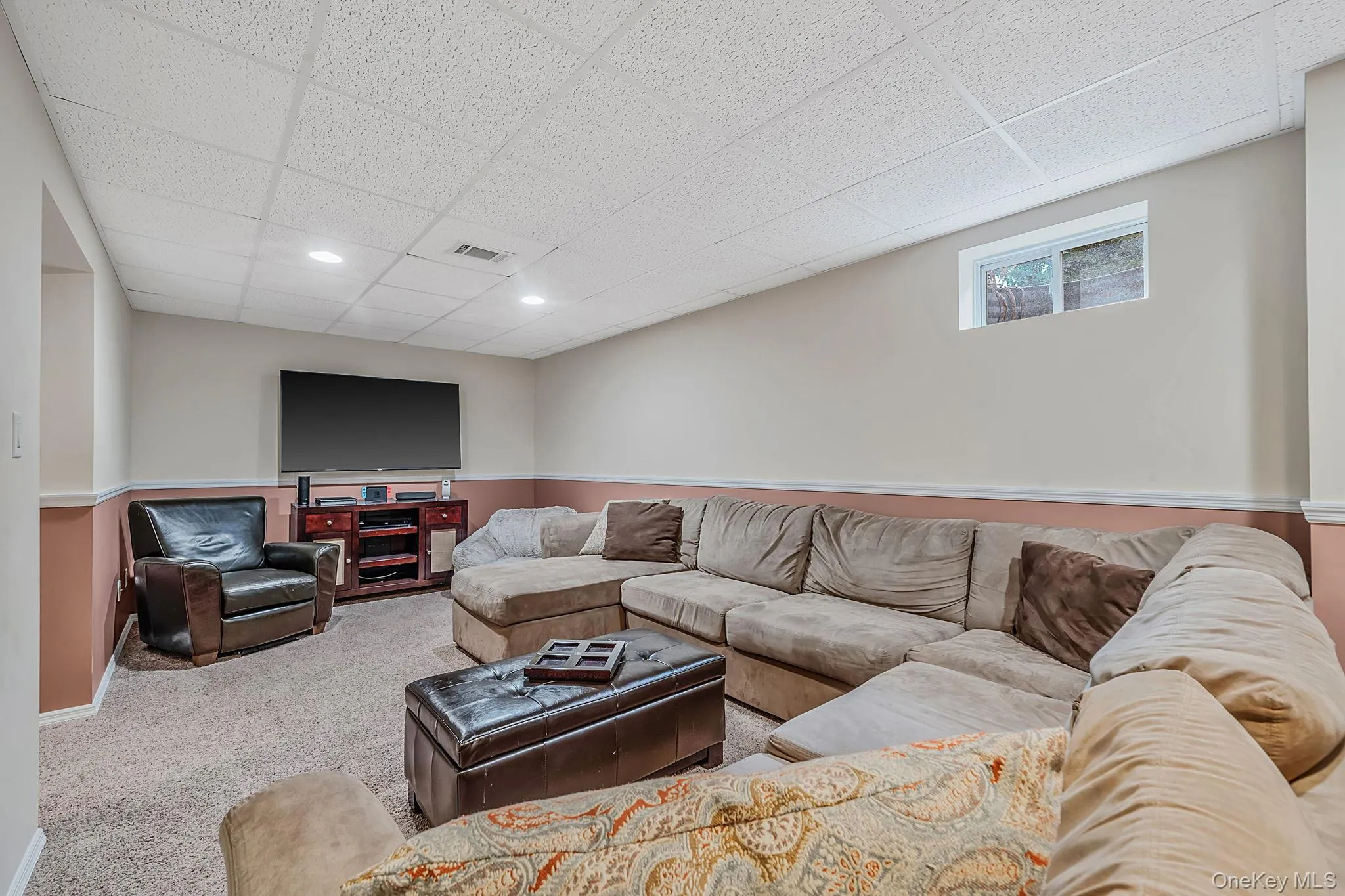 Carpeted recreation room featuring a drop ceiling with recessed lighting and a window Carpeted recreation room featuring a drop ceiling with recessed lighting and a window