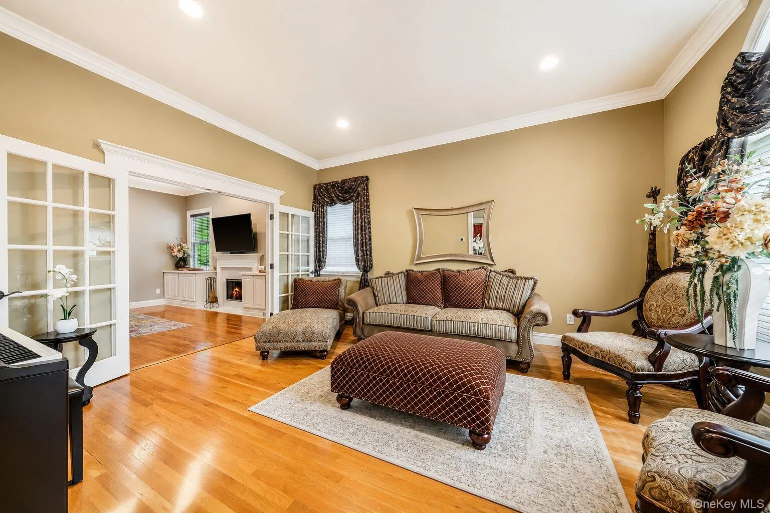 Hardwood flooring throughout, recessed lighting, crown molding, and French doors creating an open archway Hardwood flooring throughout, recessed lighting, crown molding, and French doors creating an open archway