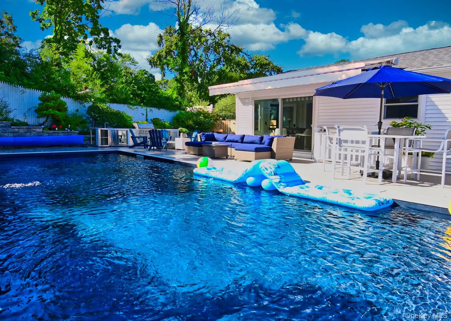 Resort-style inground swimming pool with crystal-clear water, complemented by a spacious poolside deck and mature landscaping