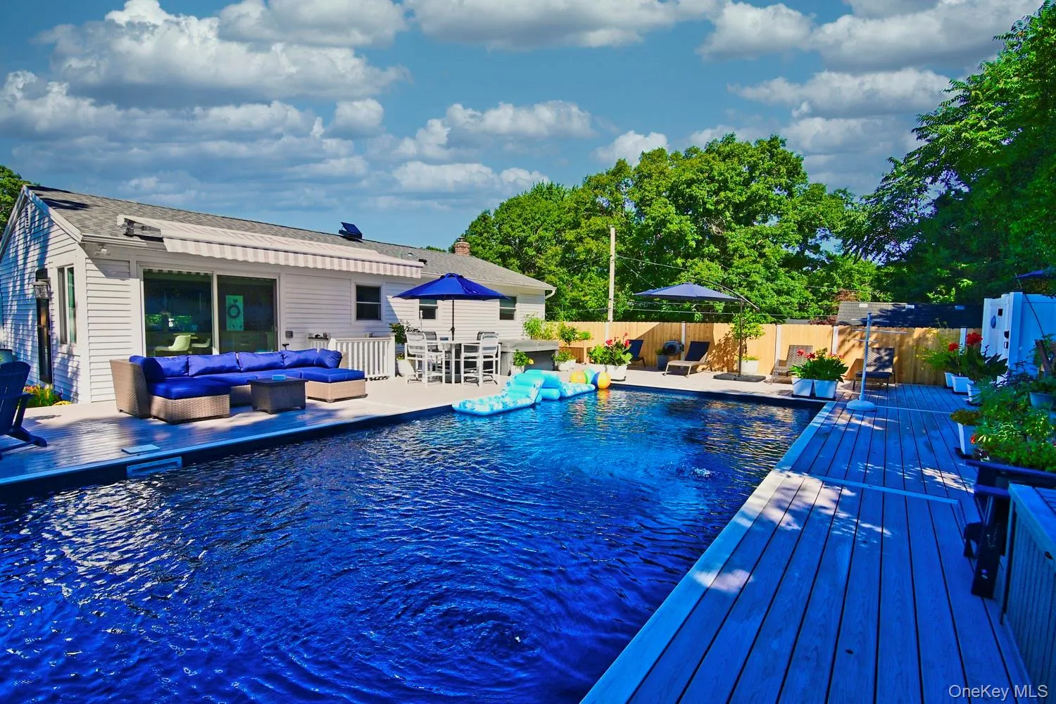 Resort-style saltwater swimming pool featuring a deep blue finish, complemented by a composite decking area with integrated seating ledges