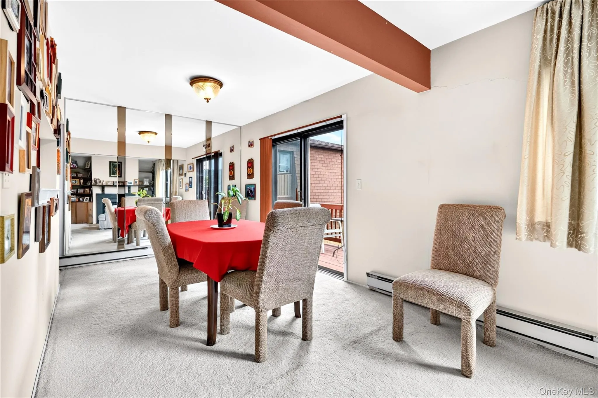 Dining area with mirrored wall and deck access. Dining area with mirrored wall and deck access.
