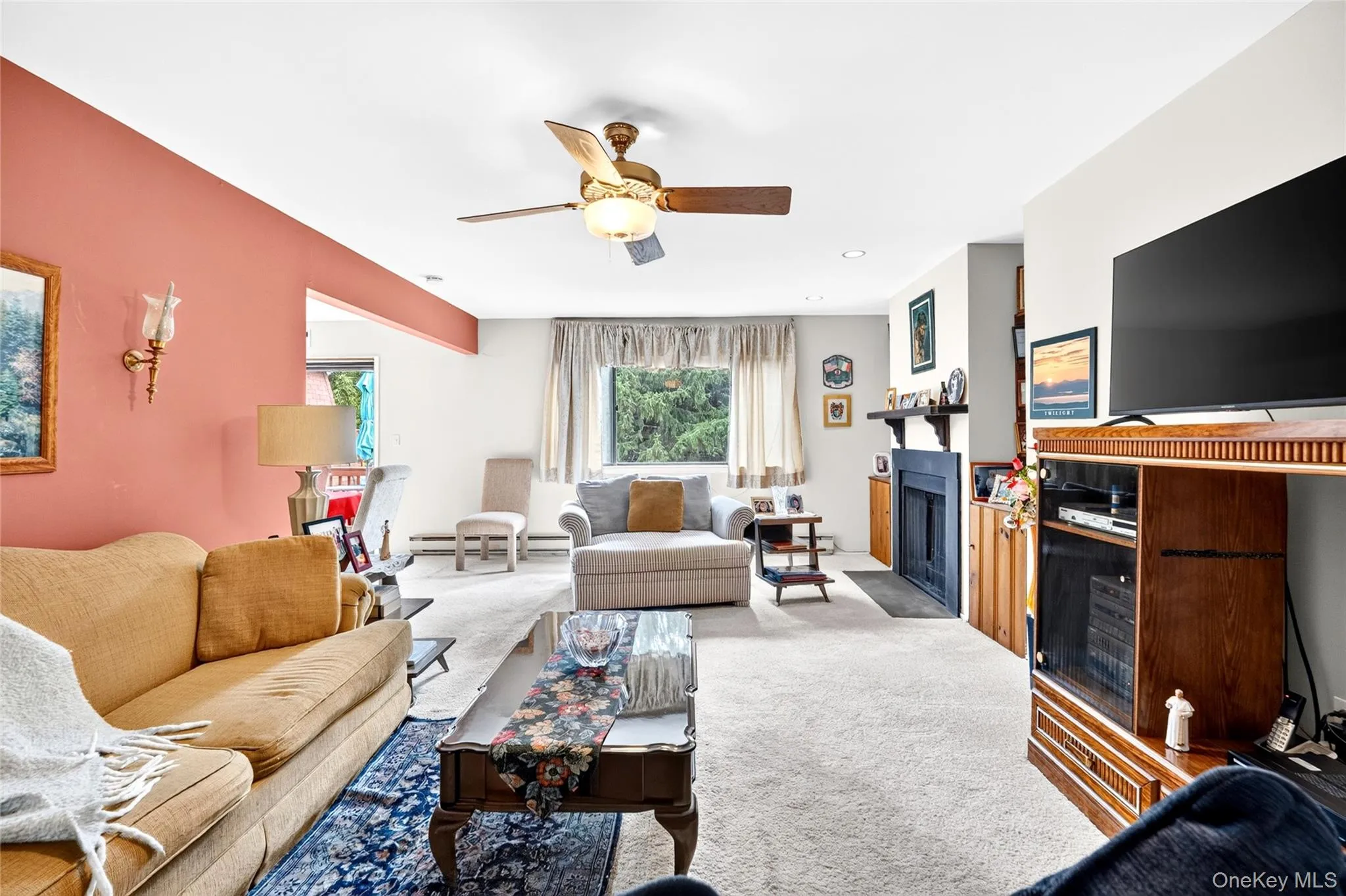 Living room featuring a fireplace and ceiling fan. Living room featuring a fireplace and ceiling fan.