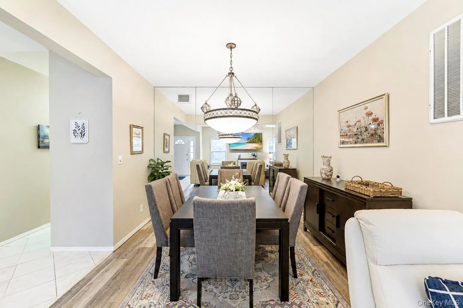Dining area with a decorative chandelier, and a mirrored accent wall Dining area with a decorative chandelier, and a mirrored accent wall