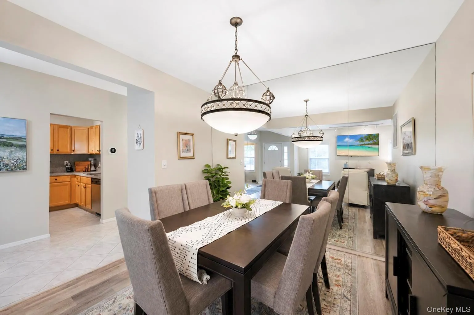 Dining area featuring two hanging light fixtures, wall-to-wall mirror panels Dining area featuring two hanging light fixtures, wall-to-wall mirror panels