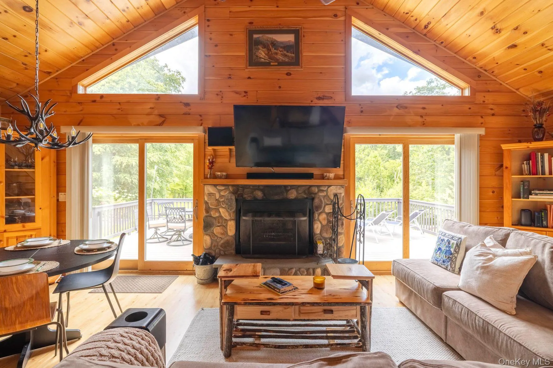 Two sets of sliding doors, complemented by upper windows, bring abundant natural light into the great room and provide direct access to the expansive deck Two sets of sliding doors, complemented by upper windows, bring abundant natural light into the great room and provide direct access to the expansive deck