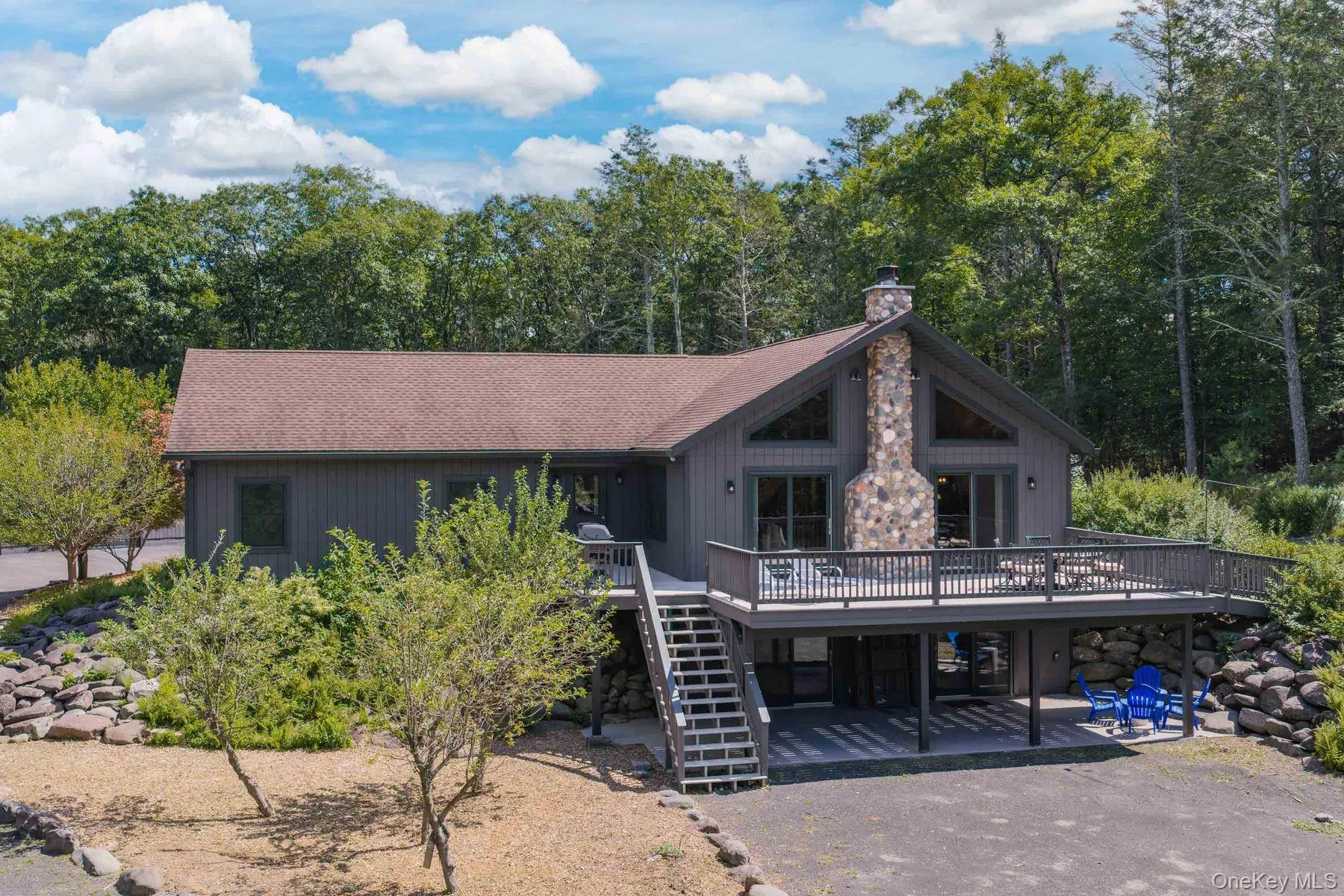 The expansive deck wraps the main living area with the stone chimney and vaulted great room creating a striking focal point. The expansive deck wraps the main living area with the stone chimney and vaulted great room creating a striking focal point.