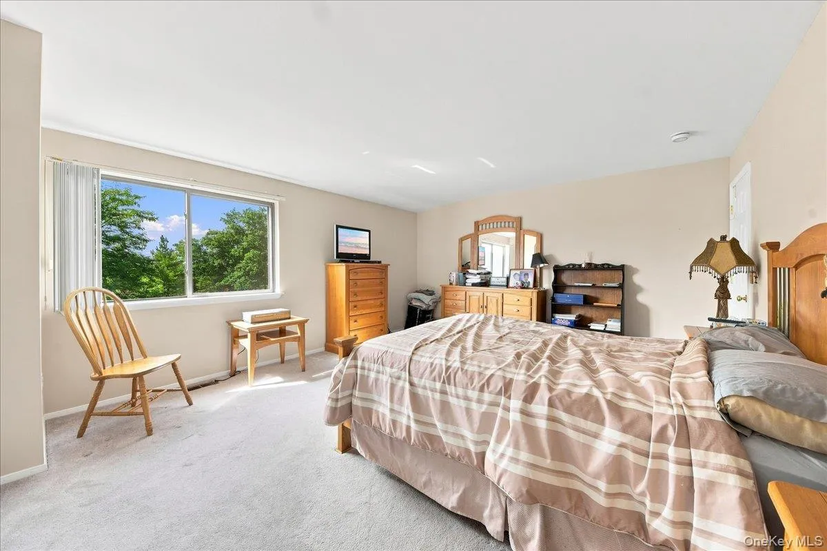 Broad window with outdoor scenery, light-toned walls, and soft carpet flooring Broad window with outdoor scenery, light-toned walls, and soft carpet flooring