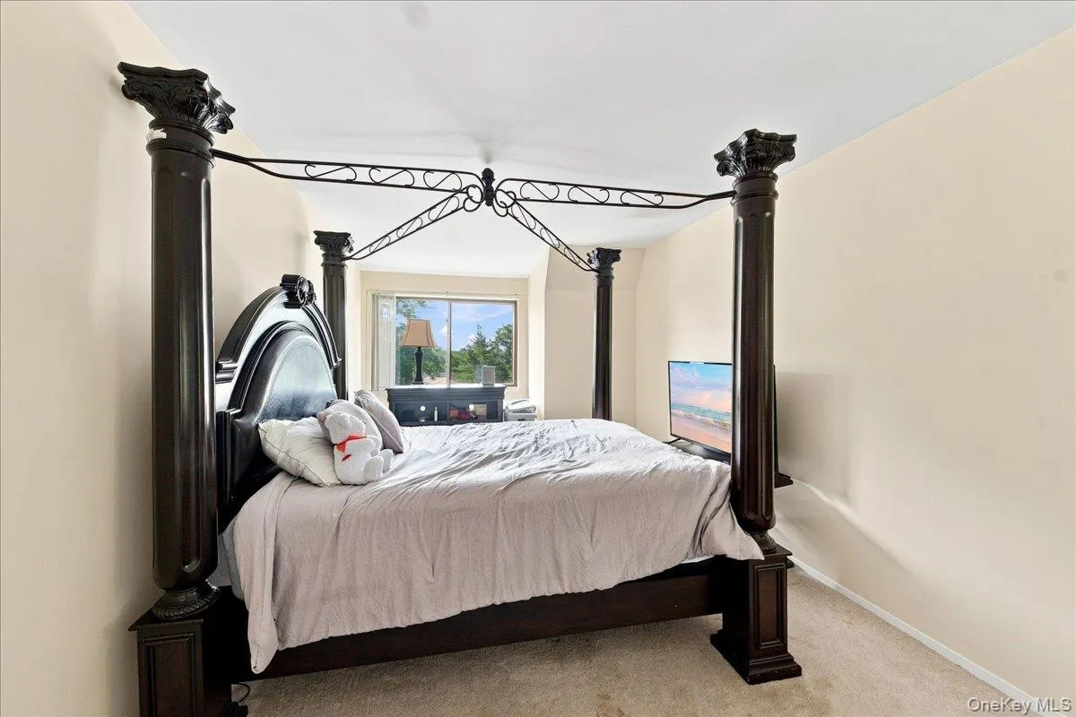 Carpeted flooring with light-toned walls and a window overlooking exterior greenery Carpeted flooring with light-toned walls and a window overlooking exterior greenery