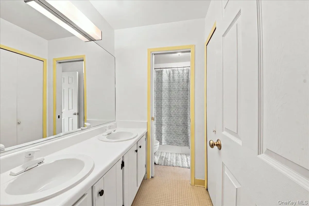 Dual vanity with integrated sinks, full-width mirror, and built-in cabinetry Dual vanity with integrated sinks, full-width mirror, and built-in cabinetry