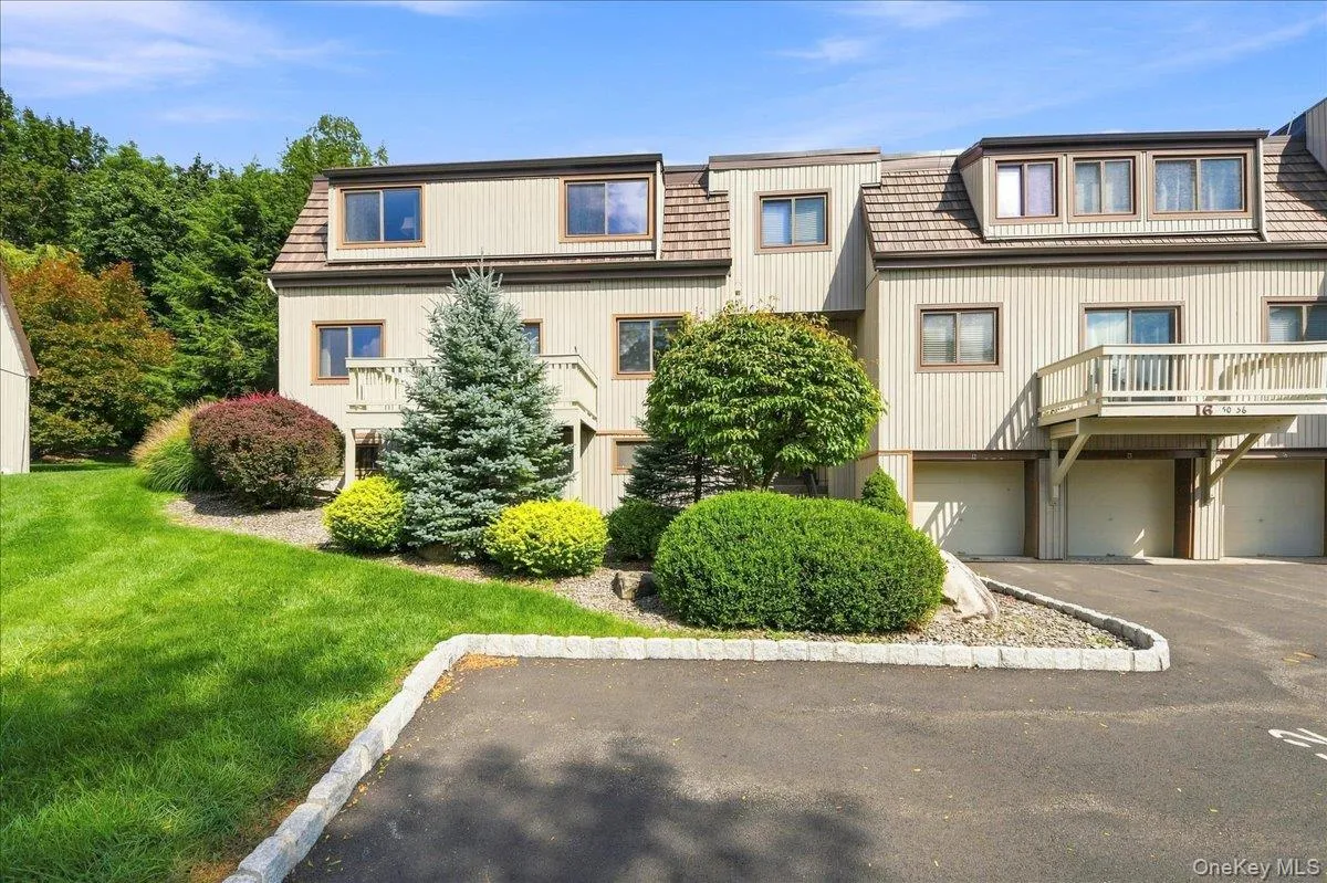Multi-level townhome exterior featuring dormer windows, a wood-shingle roof, and a private balcony Multi-level townhome exterior featuring dormer windows, a wood-shingle roof, and a private balcony