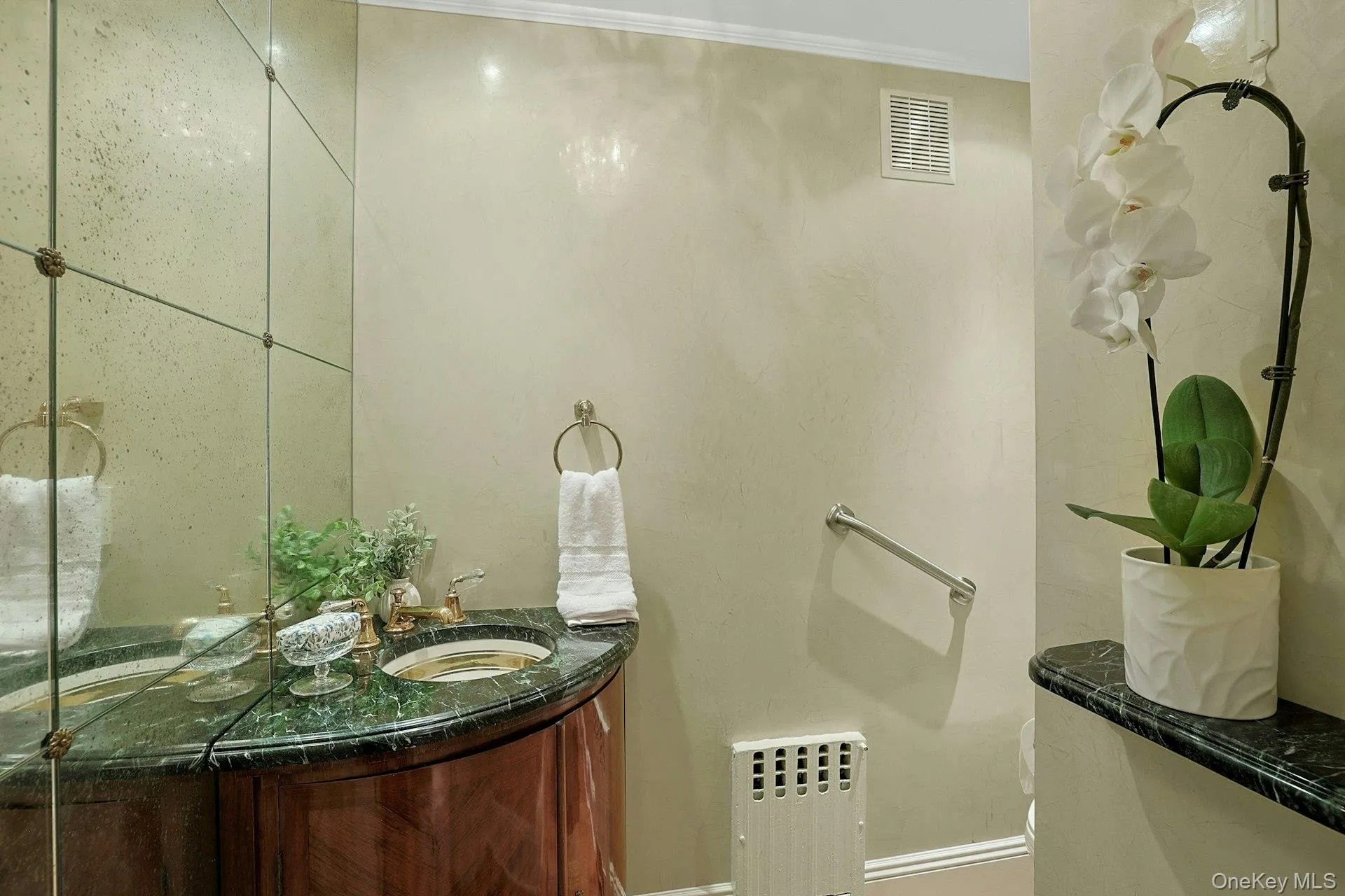 A chic first-floor powder room features beautiful Venetian plaster walls and an elegant vanity, adding a sophisticated finishing touch to the main level. A chic first-floor powder room features beautiful Venetian plaster walls and an elegant vanity, adding a sophisticated finishing touch to the main level.