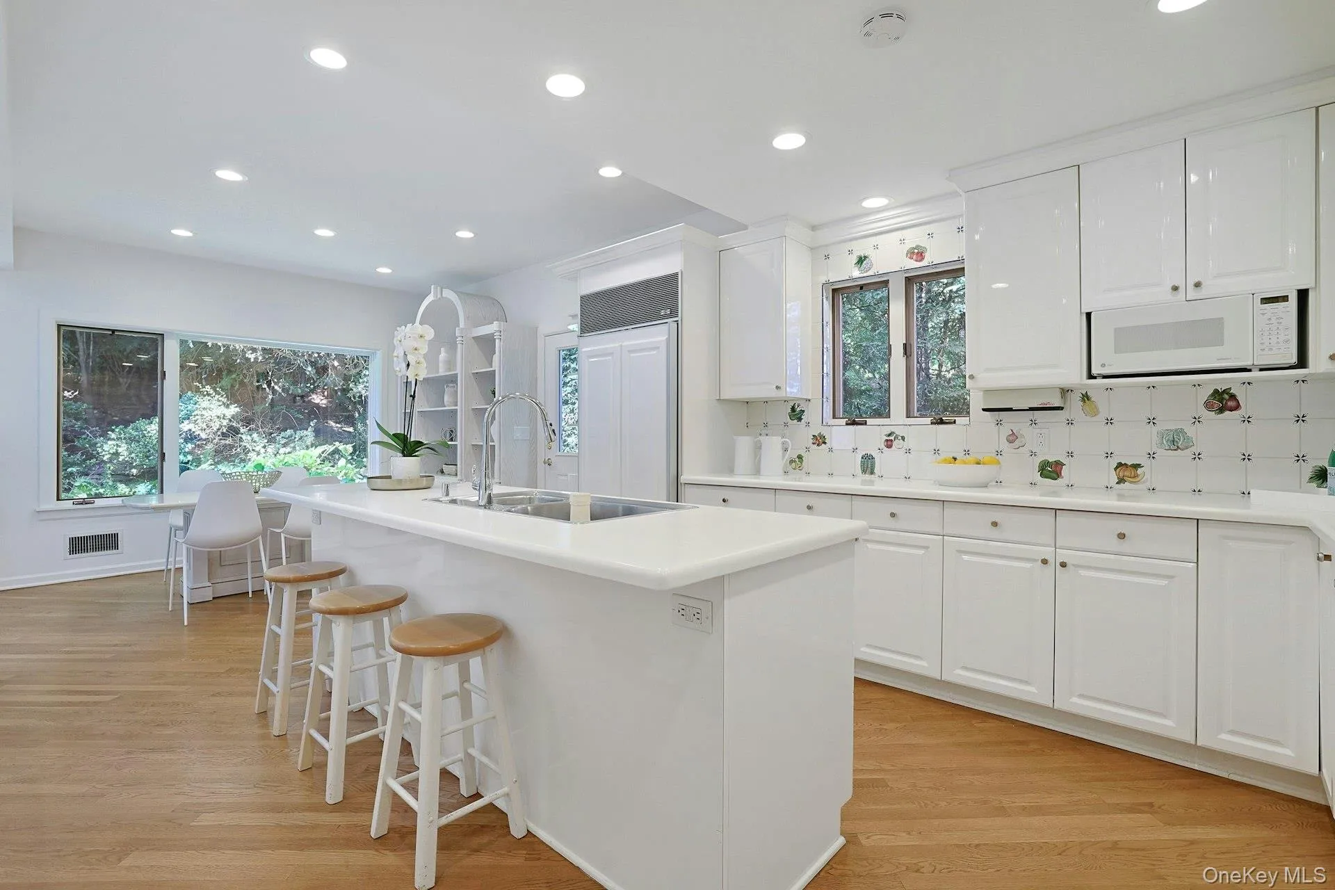 The spacious kitchen features crisp white cabinetry, premium appliances and an oversized center island with seating for casual meals and conversation. The spacious kitchen features crisp white cabinetry, premium appliances and an oversized center island with seating for casual meals and conversation.